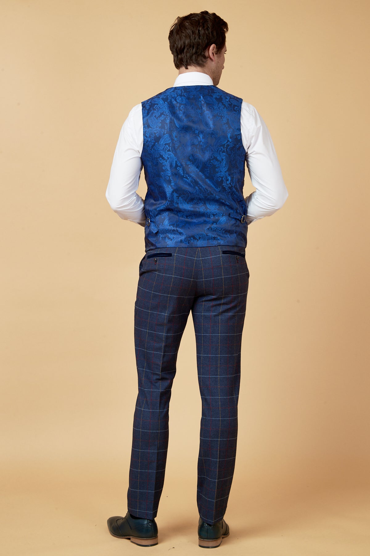 A man is seen from behind wearing a white shirt, the marcdarcy DRAKE Navy Check Waistcoat, and navy plaid pants.