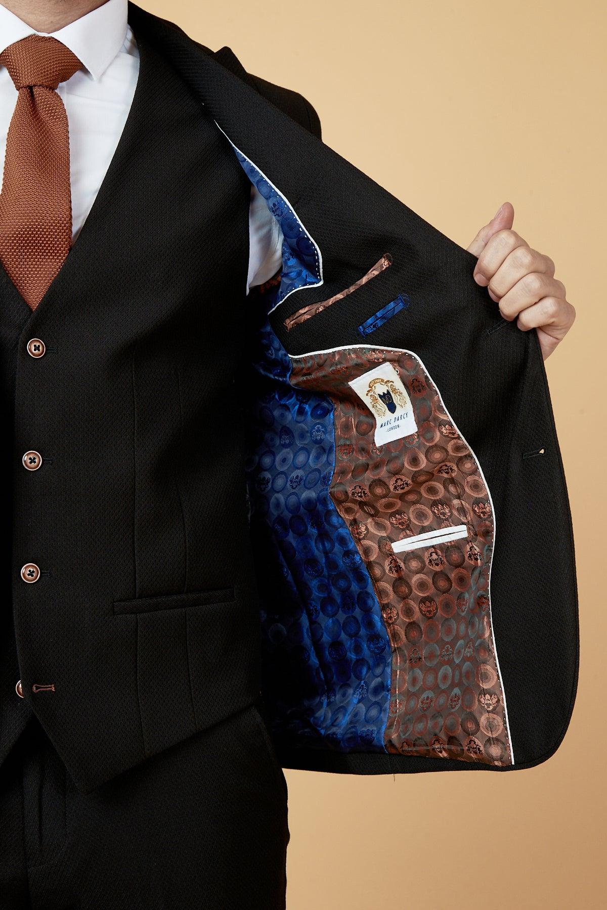 A man in the marcdarcy MAX Black Three Piece Suit with Contrast Buttons shows off the jacket’s colorful blue and brown leopard-print lining, inner pockets, and visible label, paired with a brown tie.
