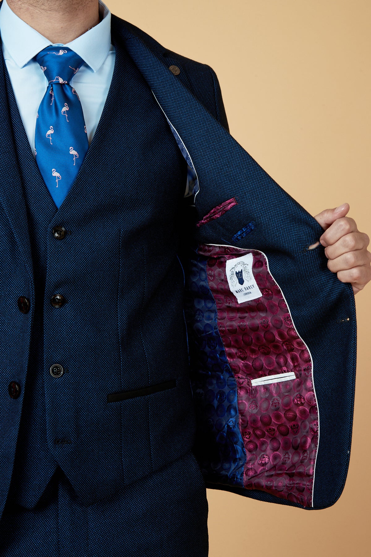 A man in a slim fit marcdarcy CALLUM Blue Blazer and blue shirt displays the unique purple and blue patterned inner lining, with a visible label and interior pocket, highlighting this distinctive blazer.