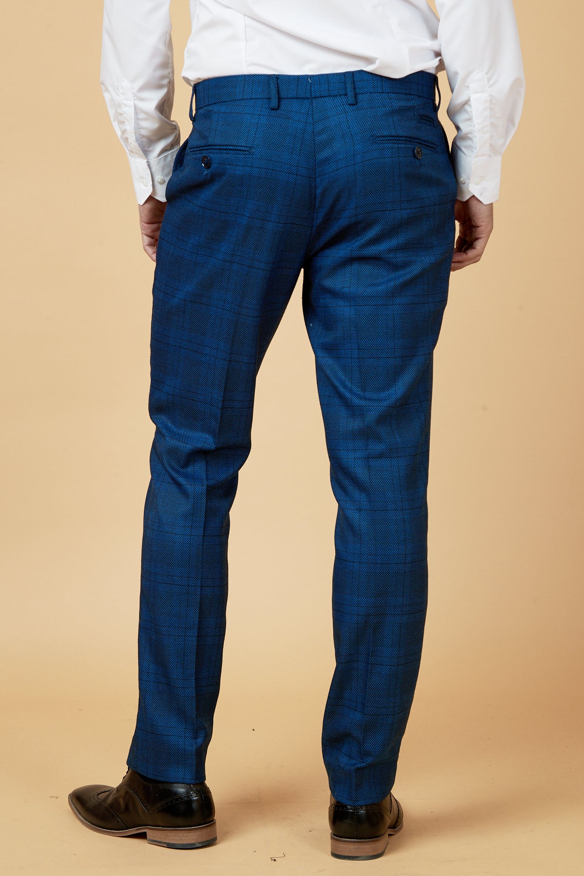 A man wears marcdarcy's JERRY Blue Check Trousers with a white shirt, ideal for a polished men's workwear look.