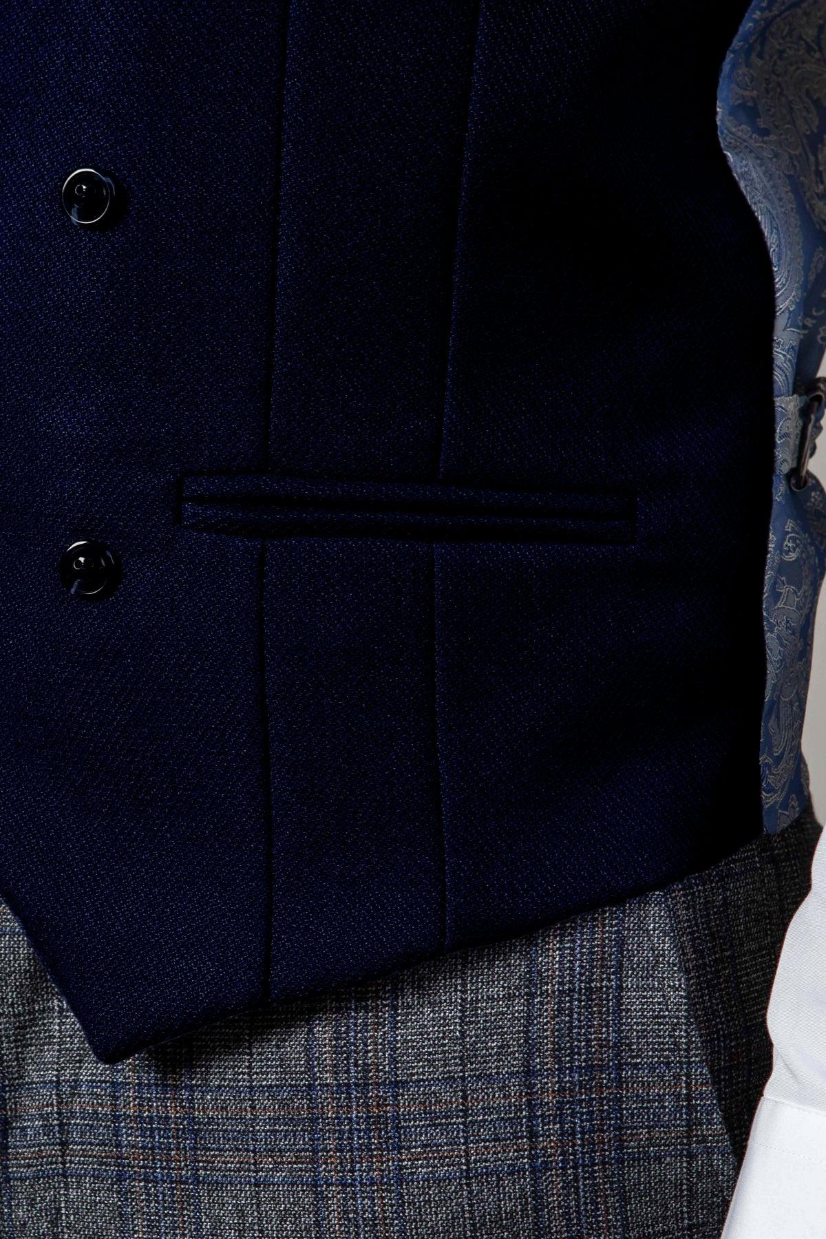 Close-up of a person in the marcdarcy KELVIN navy double-breasted waistcoat under a patterned blue and gray jacket, paired with gray plaid pants and a white shirt sleeve visible on the right.
