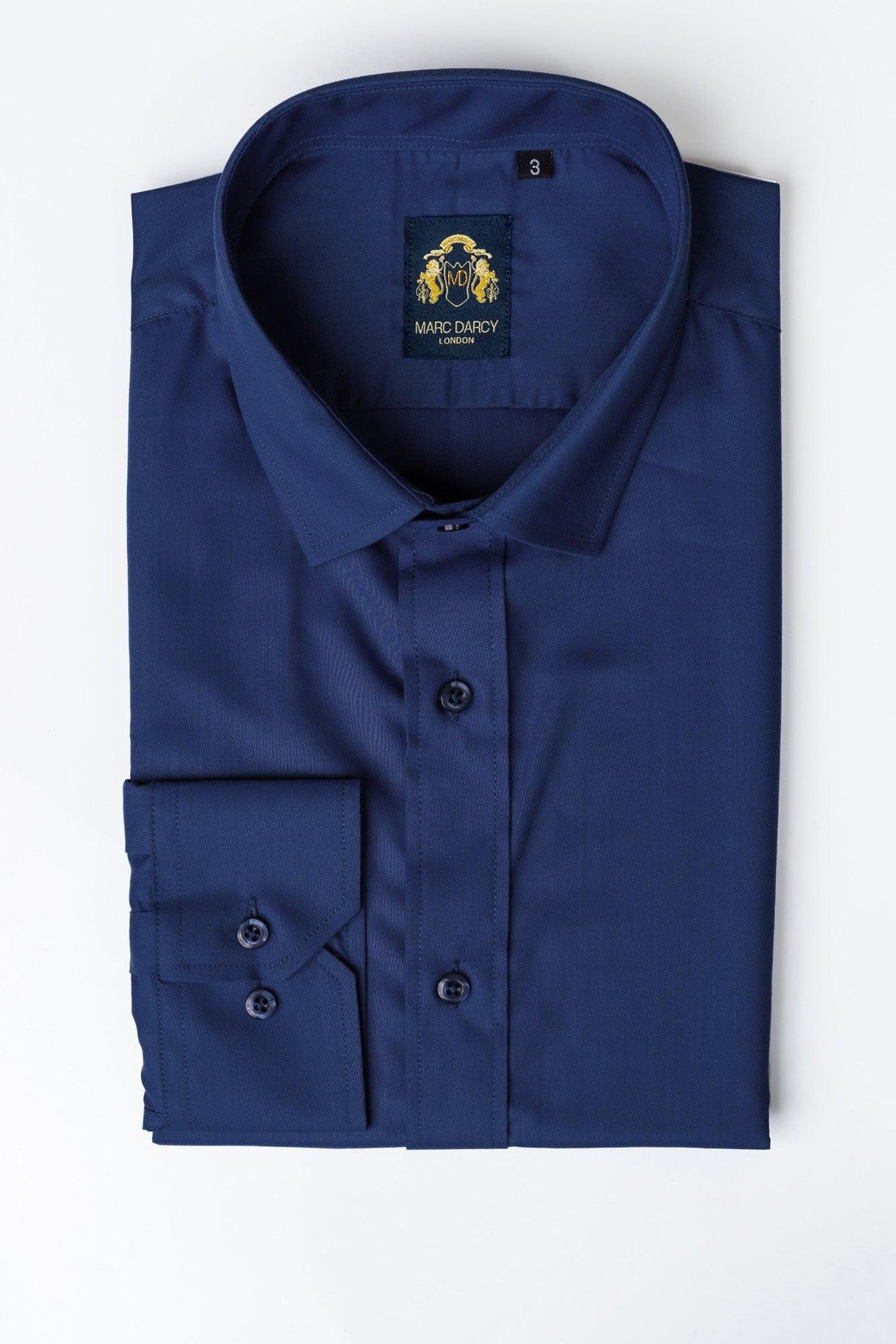 The CARTER - Blue Long Sleeve Shirt by Marc Darcy features a button-up design, pointed collar, and classic fit. A neatly folded shirt with the “Marc Darcy” label is displayed on a white background.