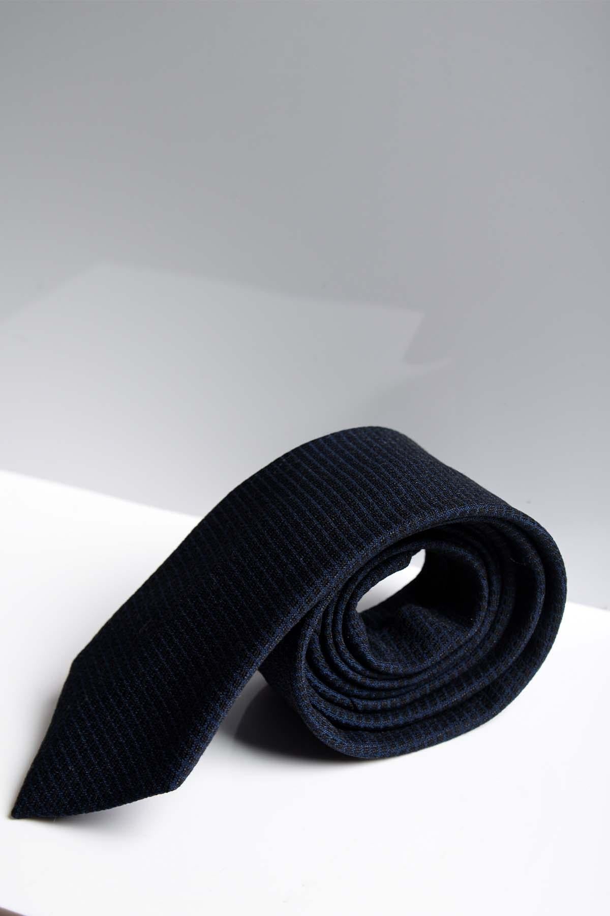 The MAX - Navy Diamond Print Tie by Accessory is rolled up on a white surface with a light grey background, ideal for formalwear or weddings.