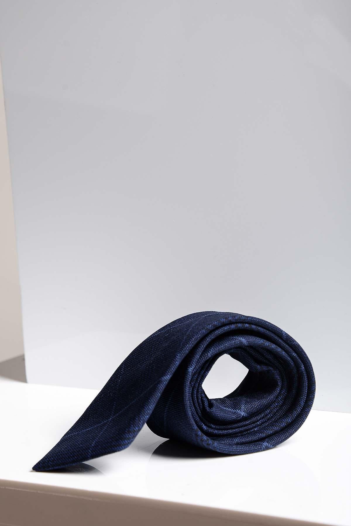 The EDINSON - Navy Sky Check Tie by Accessory is rolled up and displayed on a white surface with a light gray background.
