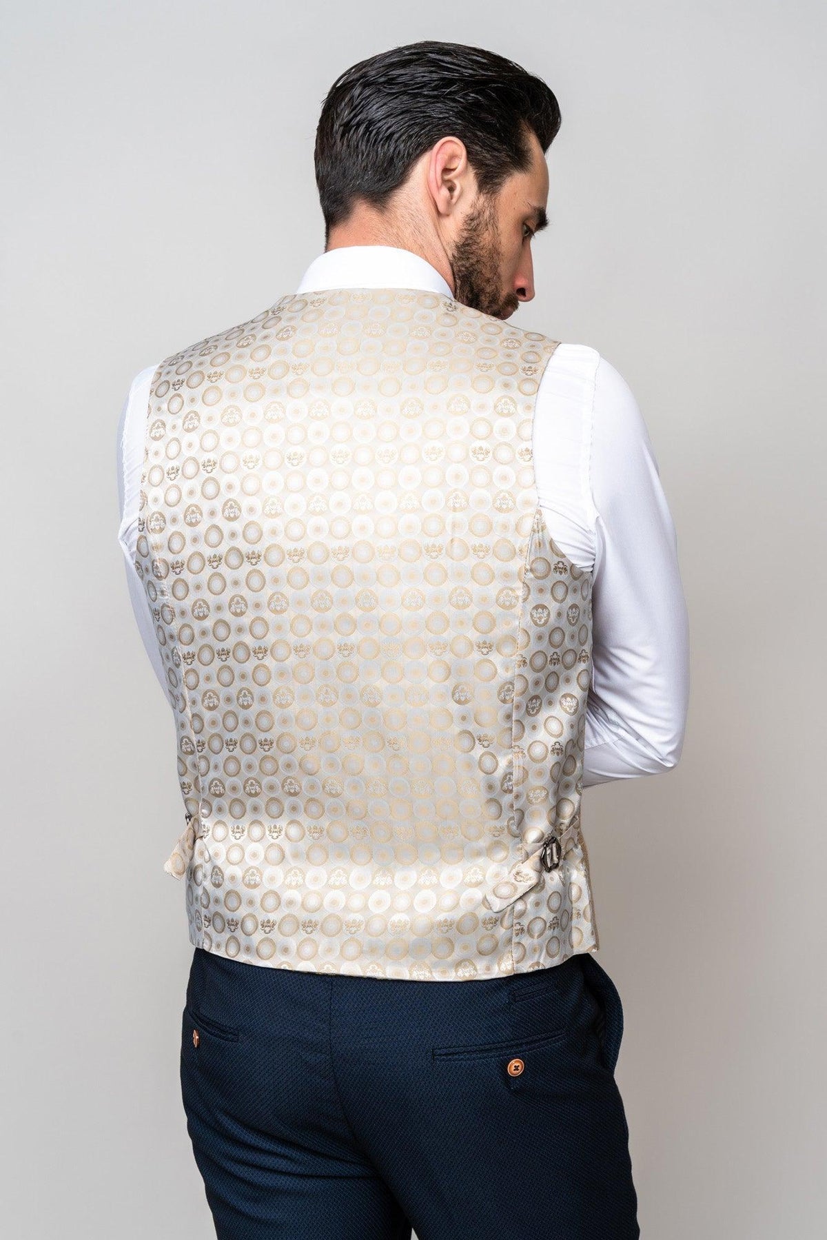 A man with dark hair, seen from behind, wears a white shirt, navy trousers, and a marcdarcy DX7 - Oak Tweed Check Waistcoat. He stands against a plain light background.