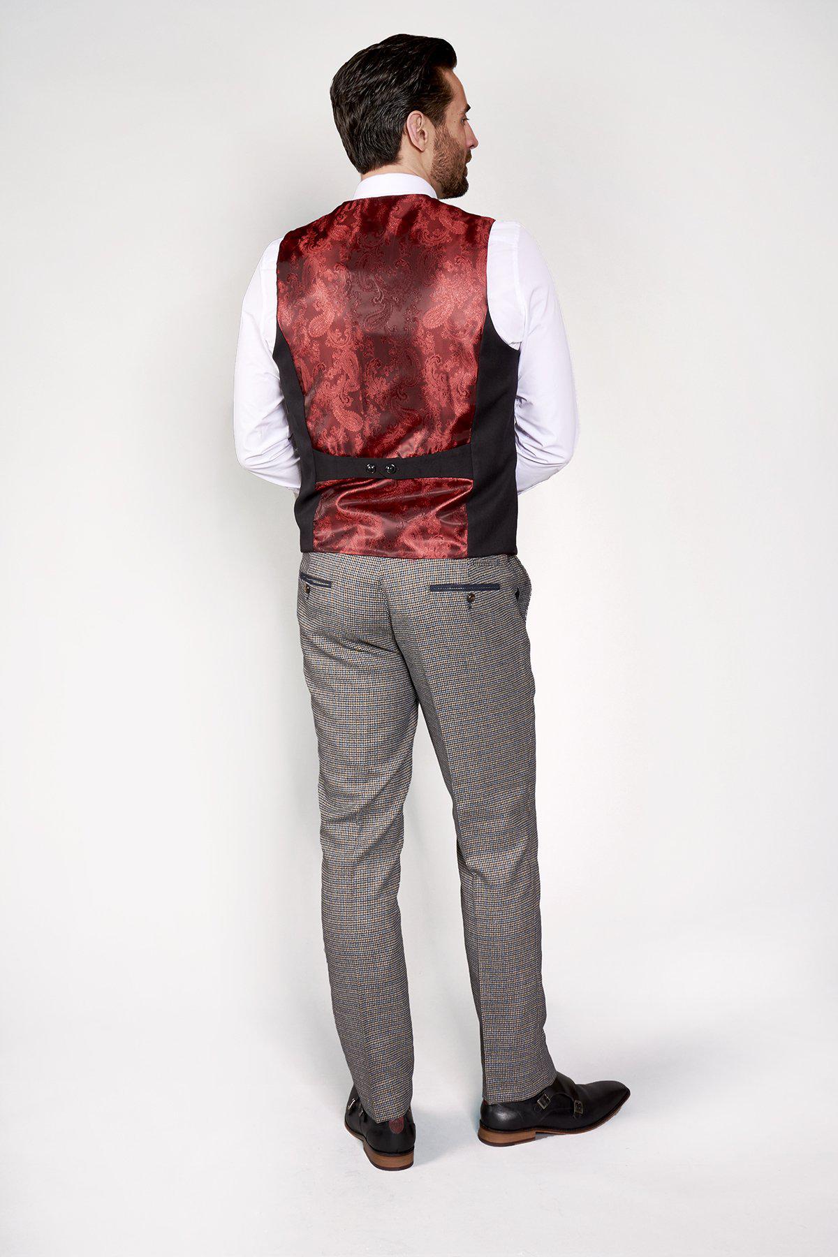 Man wearing the marcdarcy KELLY Black Single Breasted Waistcoat with red patterned lining, white shirt, and checkered pants stands from behind, highlighting a modern formalwear style.