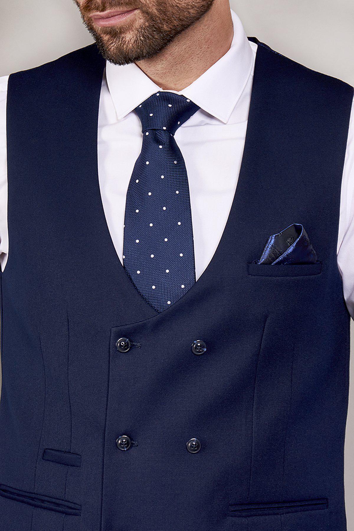 Close-up of a man wearing the marcdarcy KELLY - Blue Double Breasted Waistcoat over a white shirt, styled with a navy polka dot tie and blue patterned pocket square.