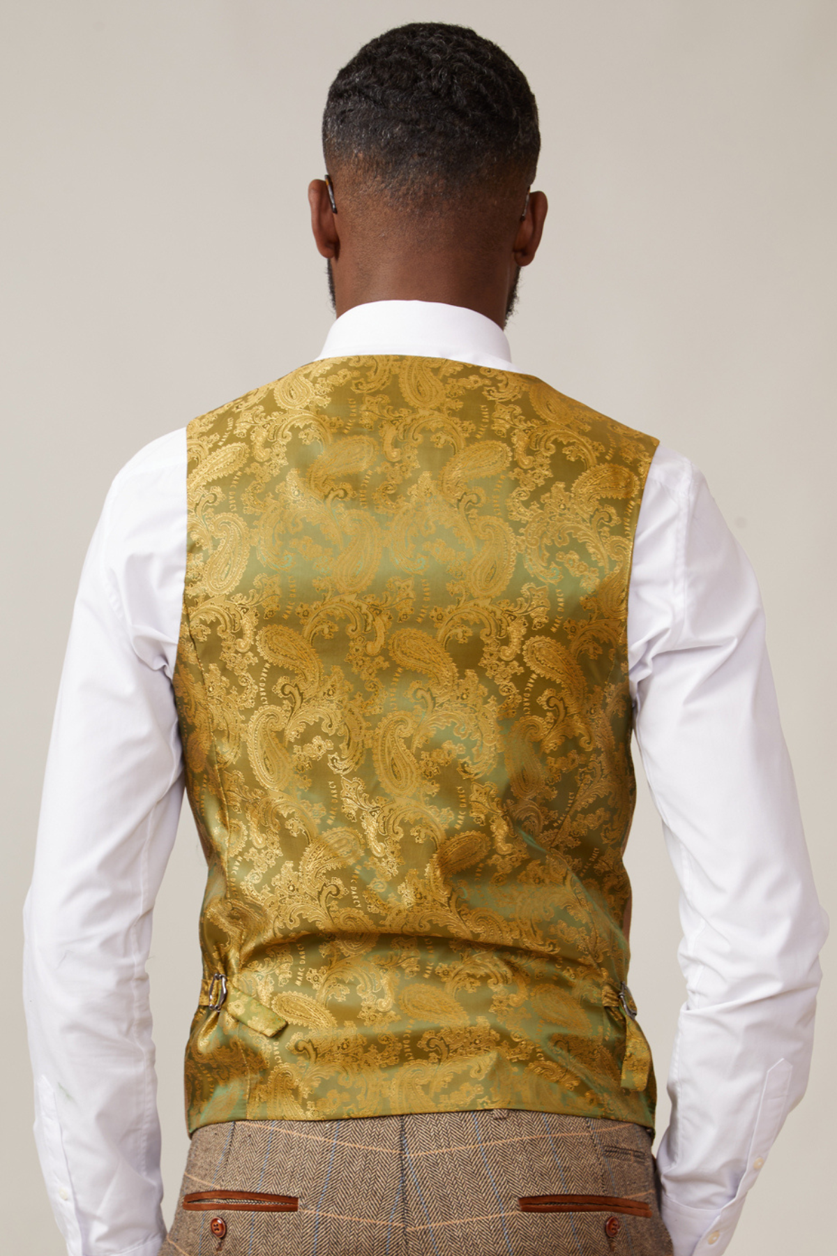 A man is seen from behind wearing the marcdarcy JENSON Grey Check Suit paired with the KELVIN Tan Waistcoat.