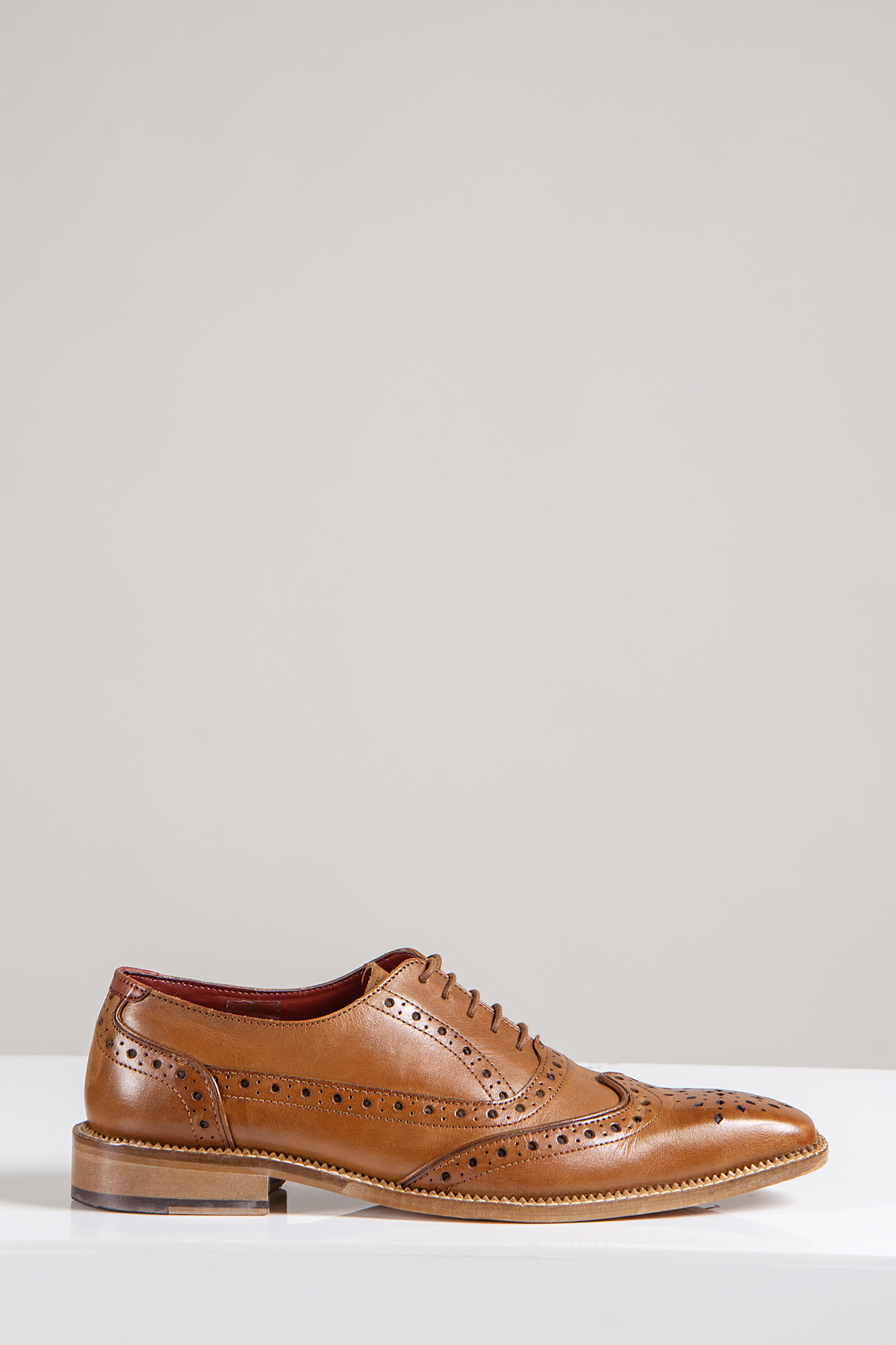 The LARKIN Mid Tan Leather Brogue Shoe by Marc Darcy features classic wingtip detailing, a men's full grain leather upper, red lining, and refined craftsmanship.