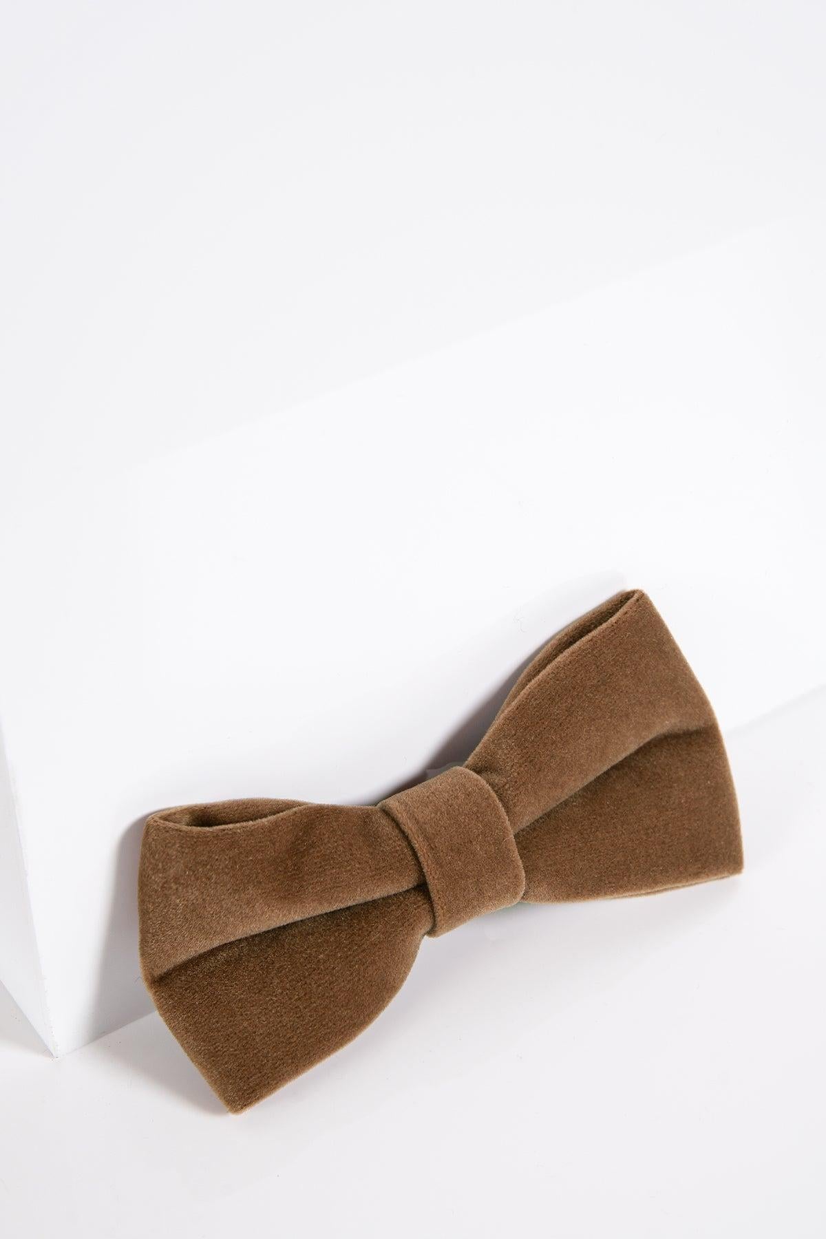 The VELVET - Light Tan Velvet Bow Tie by Accessory sits on a white surface, bringing refined charm to any black tie event.