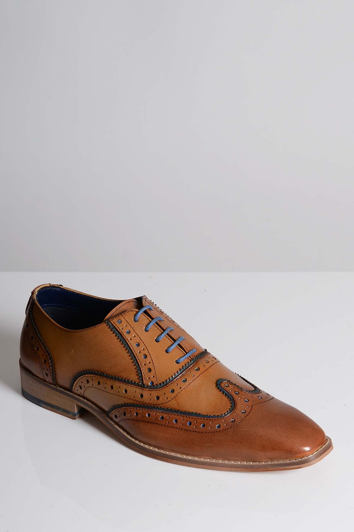 The MARCO - Tan Blue Leather Wingtip Oxford Shoe by Marc Darcy, featuring decorative perforations and blue laces, is displayed on a white surface against a light gray background.