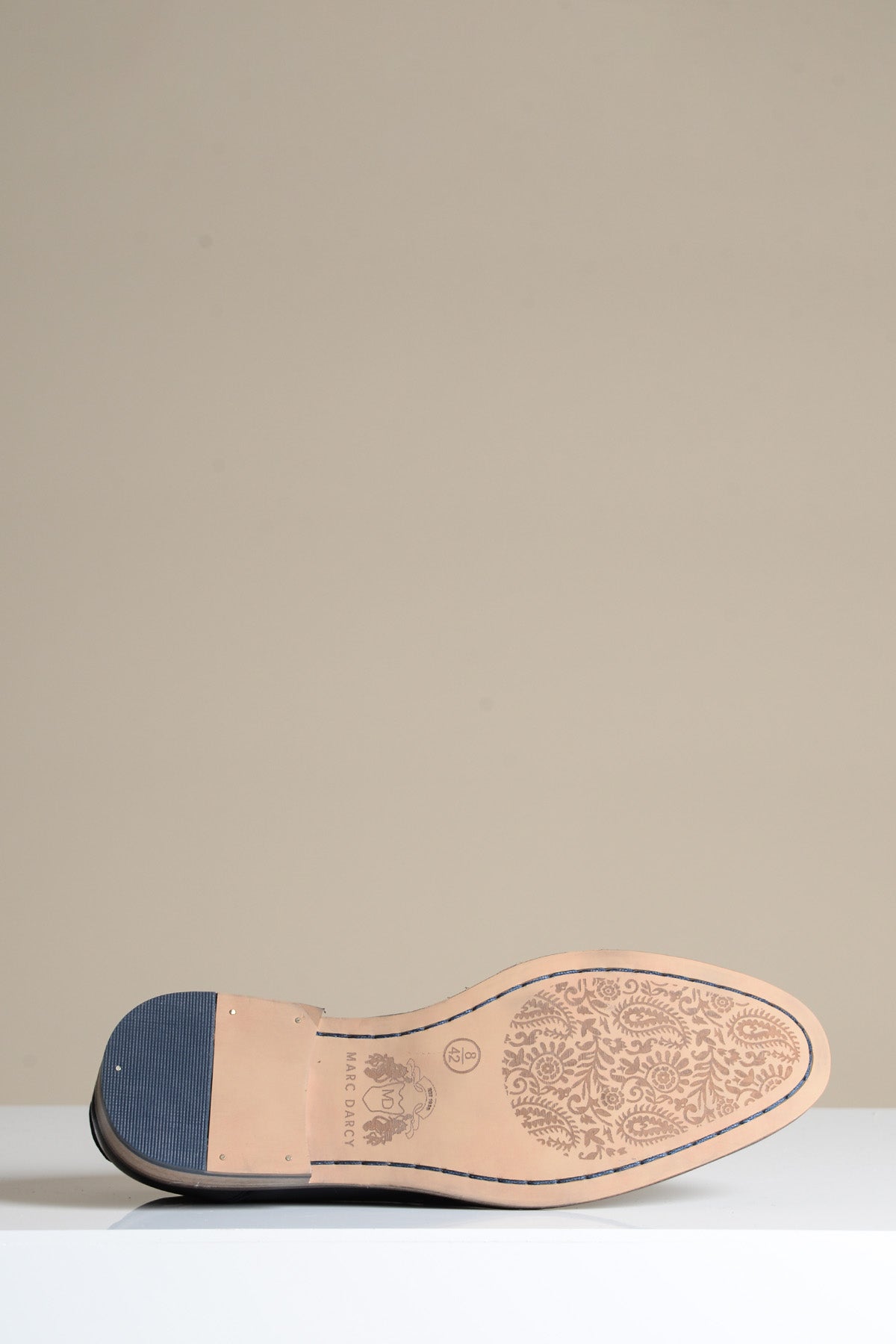 The sole of the JASPER Black Leather Penny Loafer by Marc Darcy displays ornate paisley detailing, with the brand and size 42 visible—showcasing the elegant craftsmanship of these leather dress shoes.