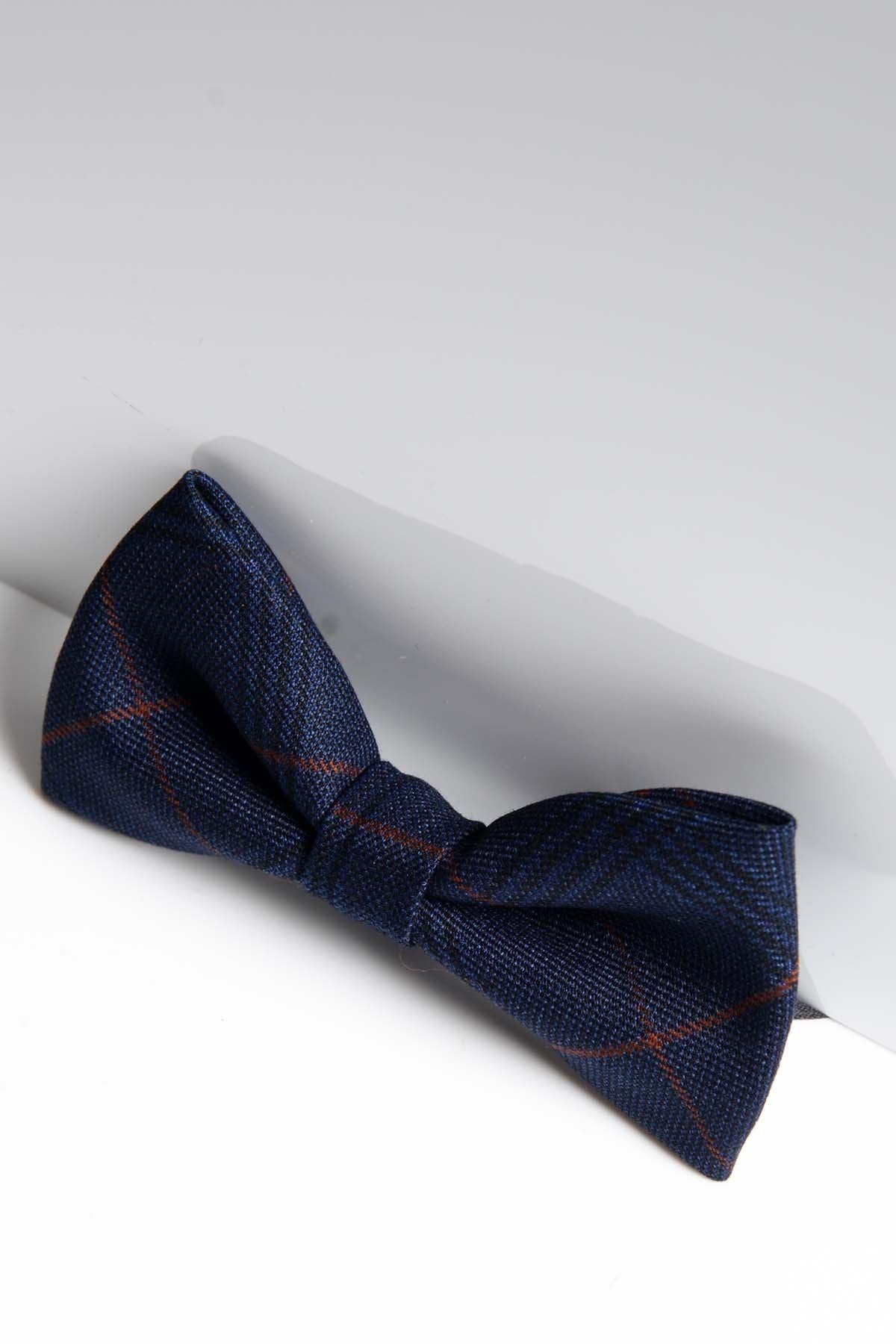 The EDINSON - Navy Wine Check Bow Tie by Accessory is a pre-tied, adjustable men's bow tie with a navy blue and subtle red plaid pattern, showcased against a white background with a reflective surface for added style.
