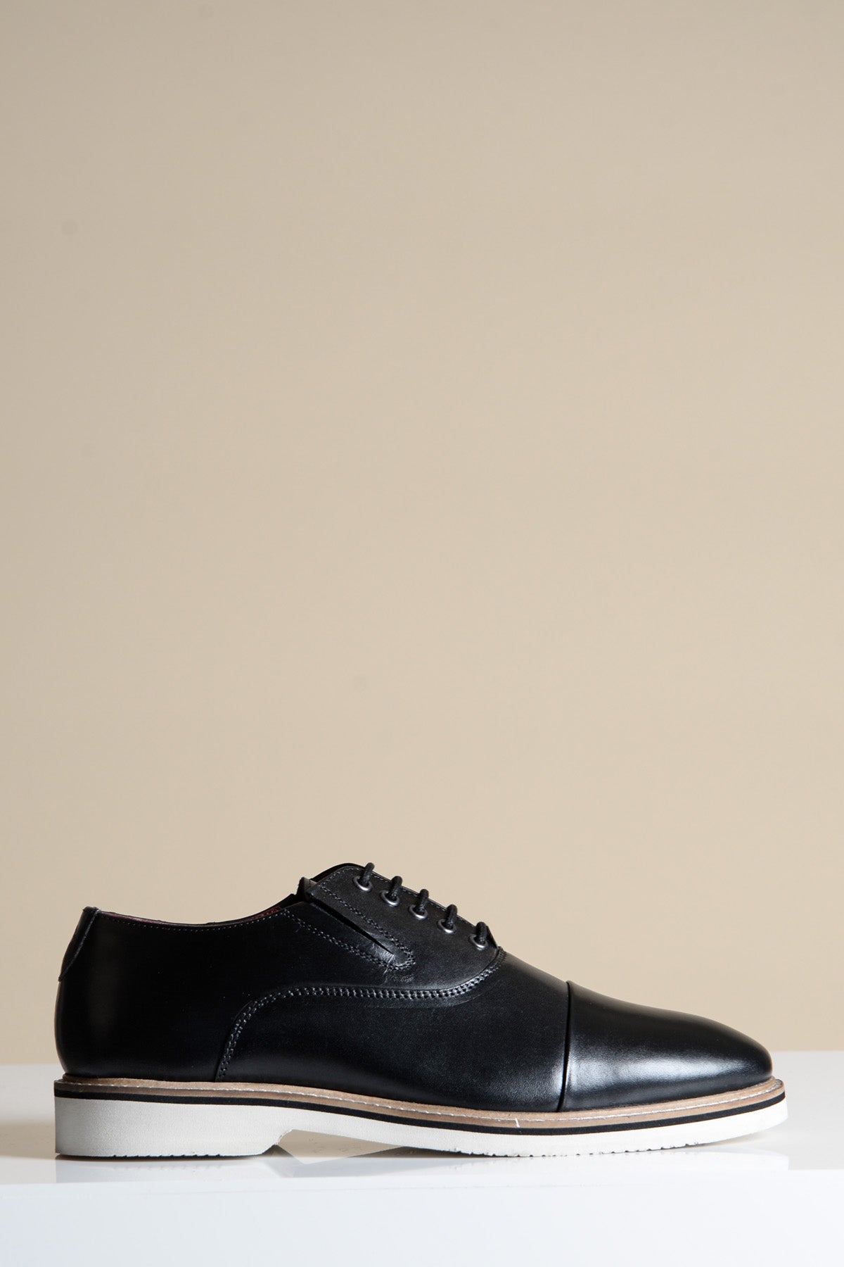 The GAVIN Black Leather Cap Toe Oxford Shoe by Marc Darcy features sleek leather with a white sole and is expertly hand-stitched for a polished finish.