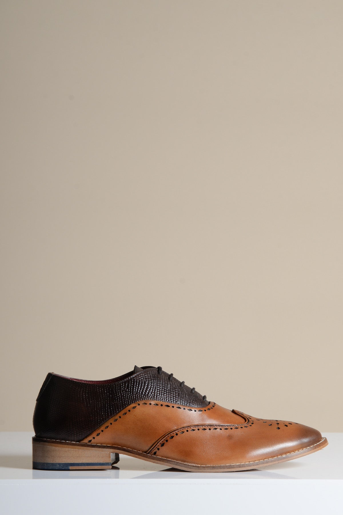 The RYAN - Tan Brown Leather Wingtip Brogue Shoe by Marc Darcy features full grain leather with textured dark brown heel and toe caps, elegant perforations, and classic broguing—ideal for formal occasions.
