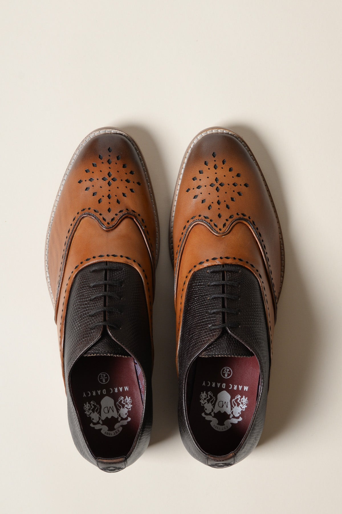 A pair of RYAN Tan Brown Leather Wingtip Brogue Shoes by Marc Darcy is shown from above on a light background. The insoles feature the Marc Darcy logo and the phrase “MADE CRAZY.”.