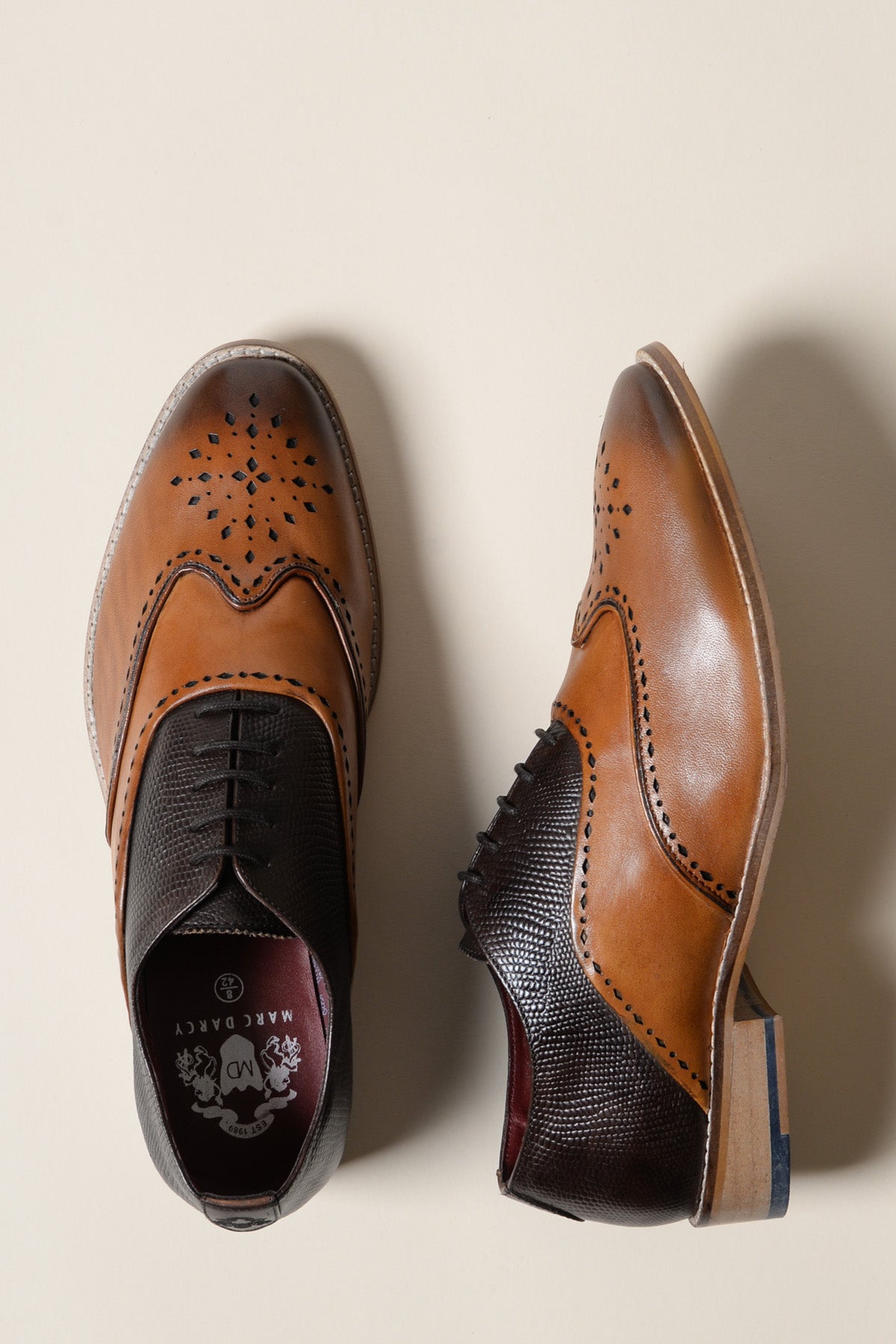 The Marc Darcy RYAN Tan Brown Leather Wingtip Brogue Shoes are shown on a light beige background, with one shoe in a top view and the other in a side view.