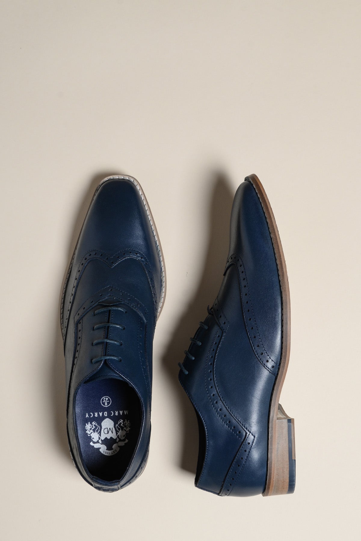 The DAWSON Navy Wingtip Oxford Brogue Shoe by Marc Darcy features full grain leather, classic brogue details, and a stacked wooden heel—ideal formal footwear for a polished look.