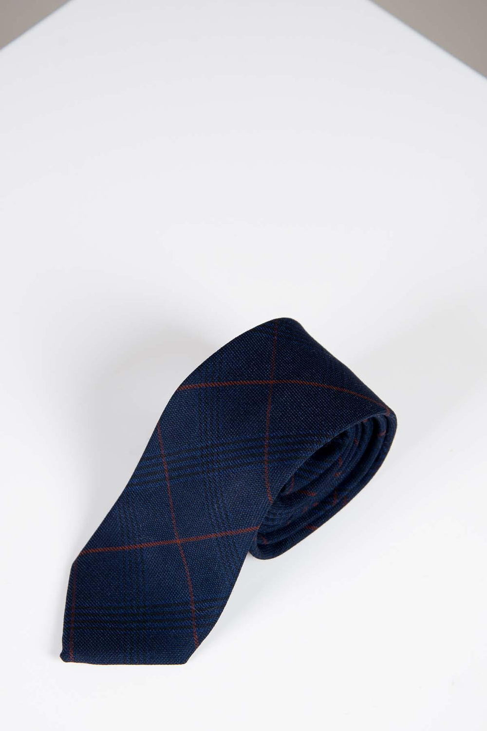 The EDINSON - Navy Wine Check Tie by Accessory features a navy base with a red windowpane pattern, offering a refined accent to formal attire.