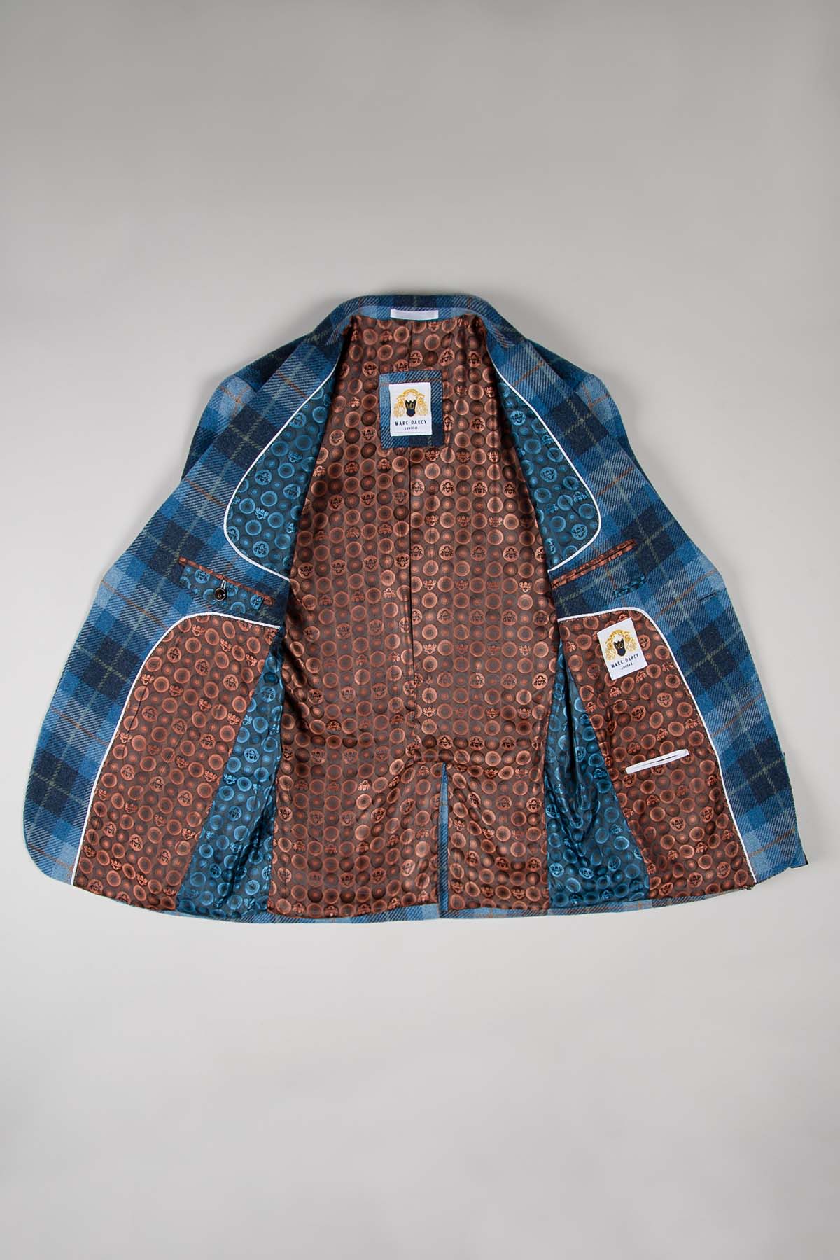 The Marc Darcy MORRIS Blue Tweed Check Blazer features a blue windowpane check design and is lined with intricate brown and blue patterns, offering a slim fit that reveals stunning interior details when opened.