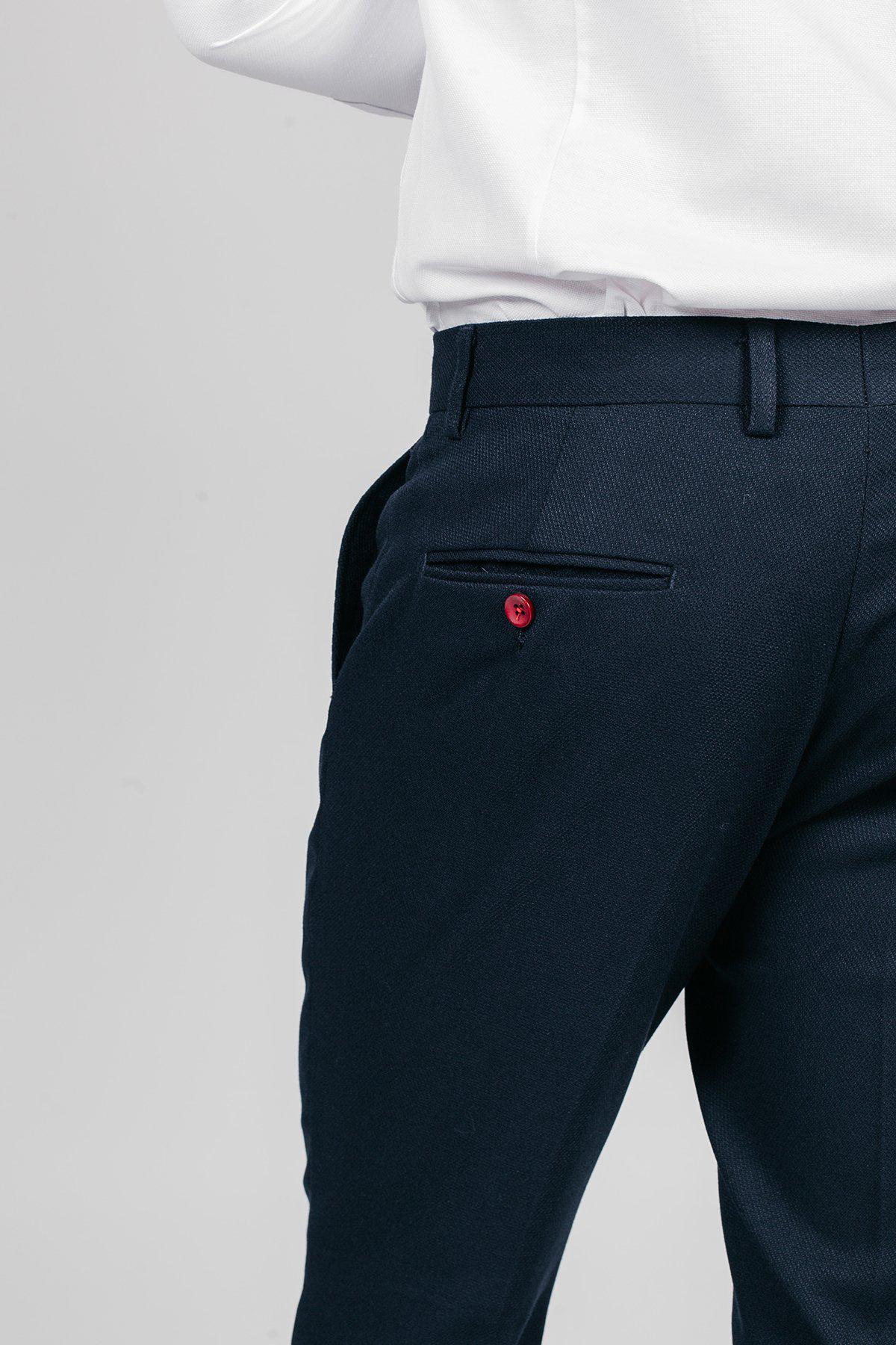 The lower torso and upper legs of a person wearing the marcdarcy Newcastle United and England Goalkeeper Nick Pope JD4 Navy Suit are visible, paired with a white shirt and featuring a red button on the back pocket, set against a plain background.