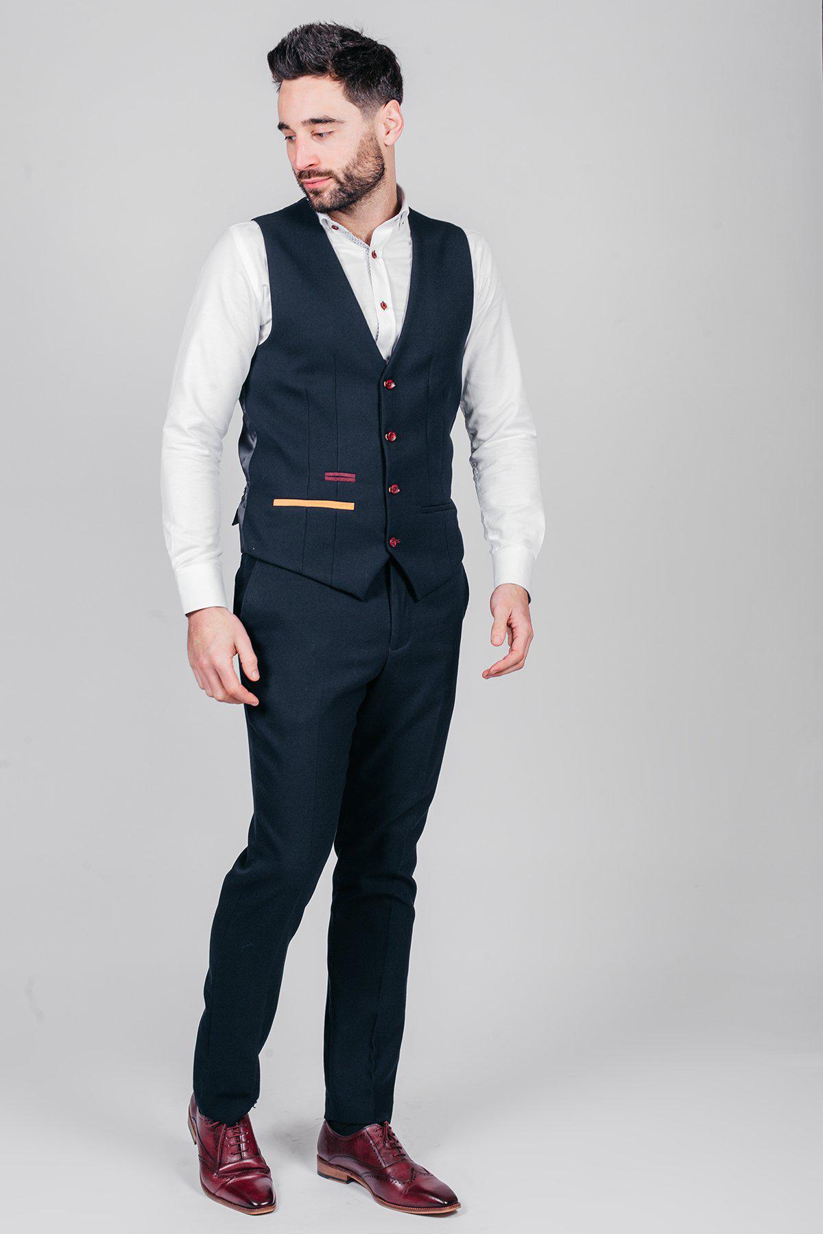 Newcastle United and England goalkeeper Nick Pope wears a marcdarcy JD4 navy suit, featuring paisley lining and matching pants, along with a white shirt and burgundy dress shoes, standing against a light gray background.