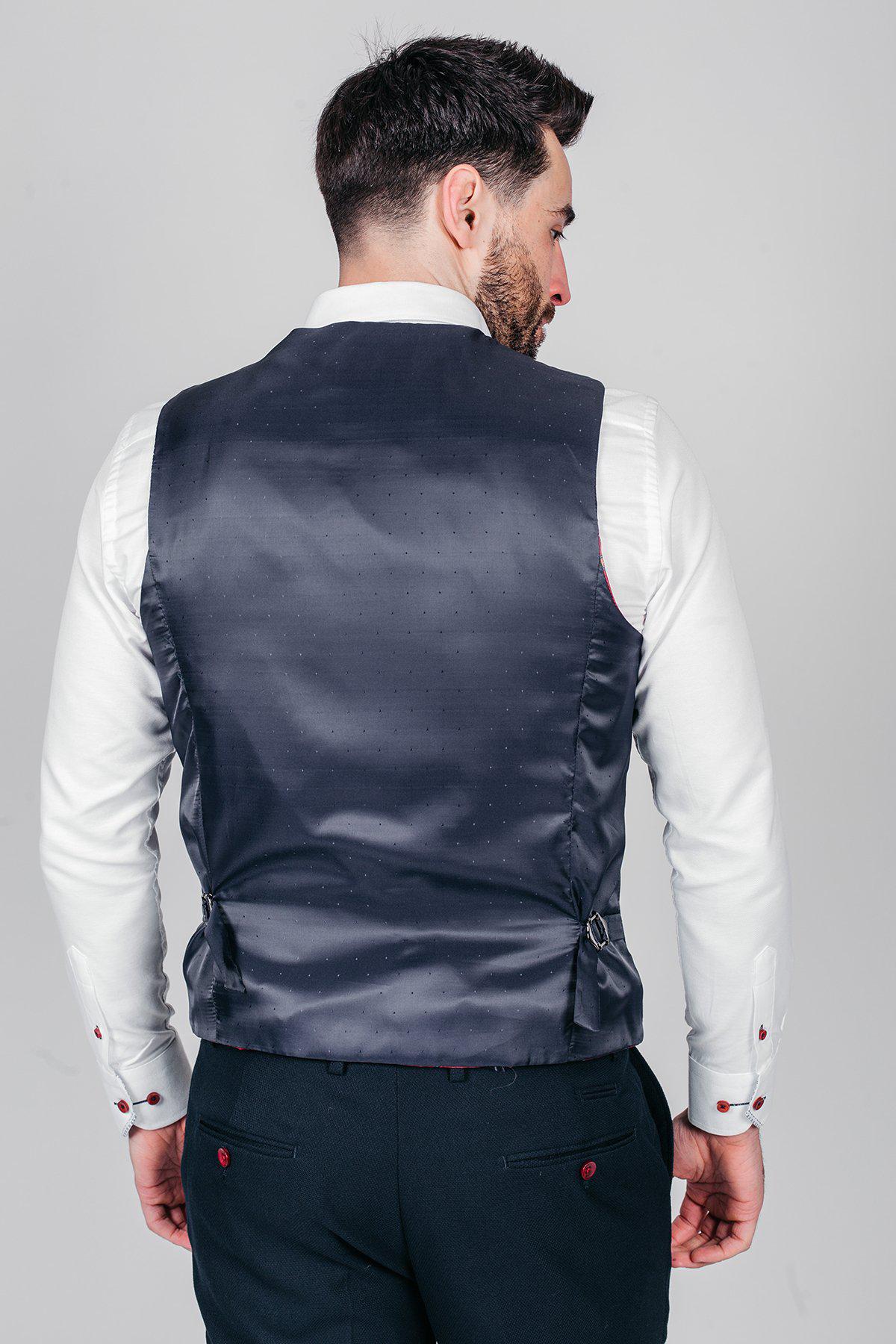 Newcastle United and England goalkeeper Nick Pope is seen from the back wearing the marcdarcy JD4 Navy Suit—featuring a white shirt, dark trousers, and a navy satin vest with subtle dots. Perfect for wedding guests or a men's three-piece look.