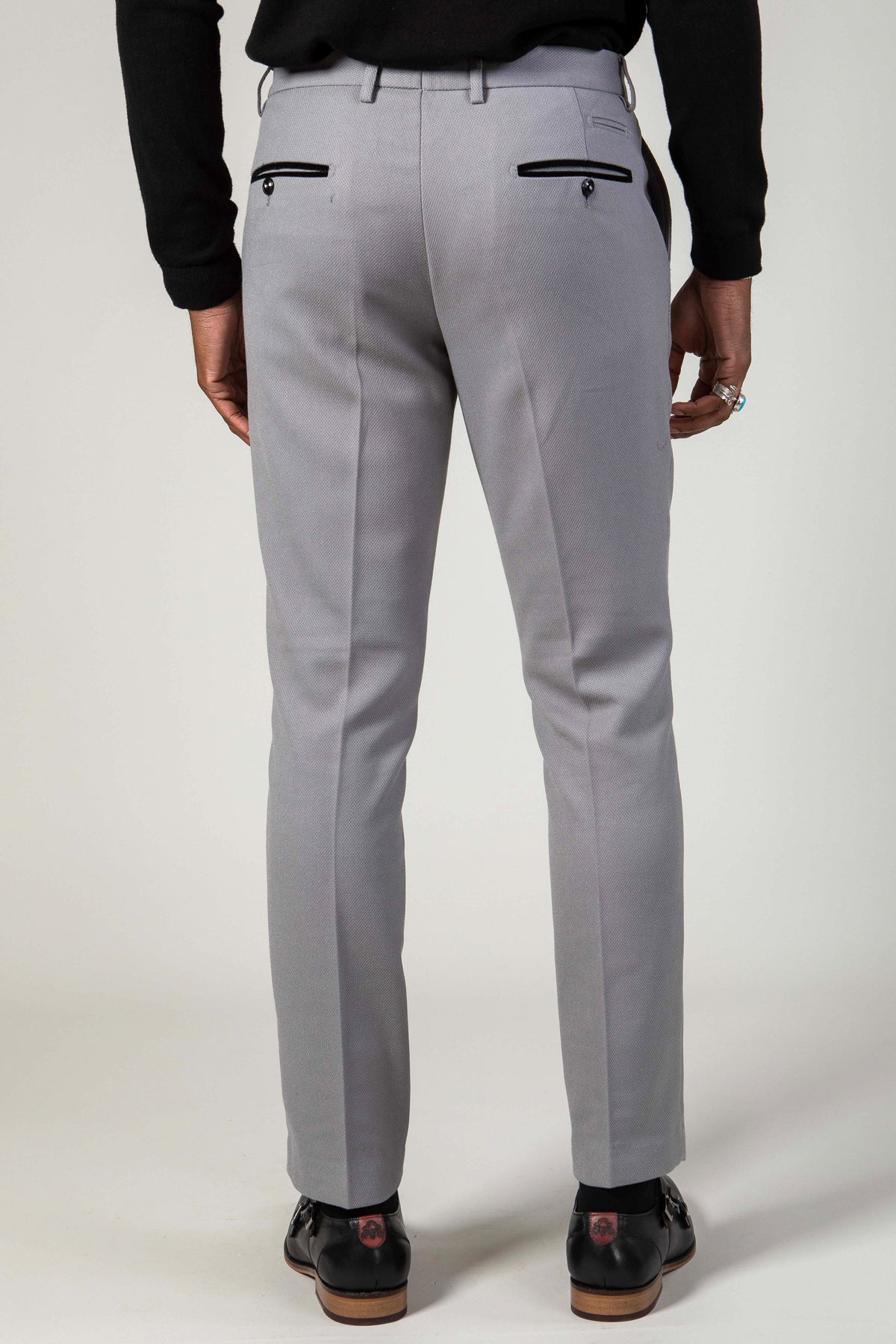 A person is seen from the back wearing marcdarcy's EDWIN Silver Grey Notch Lapel Two Piece Suit slim fit pants with two black buttoned back pockets, a black long-sleeve top, and classic black dress shoes.