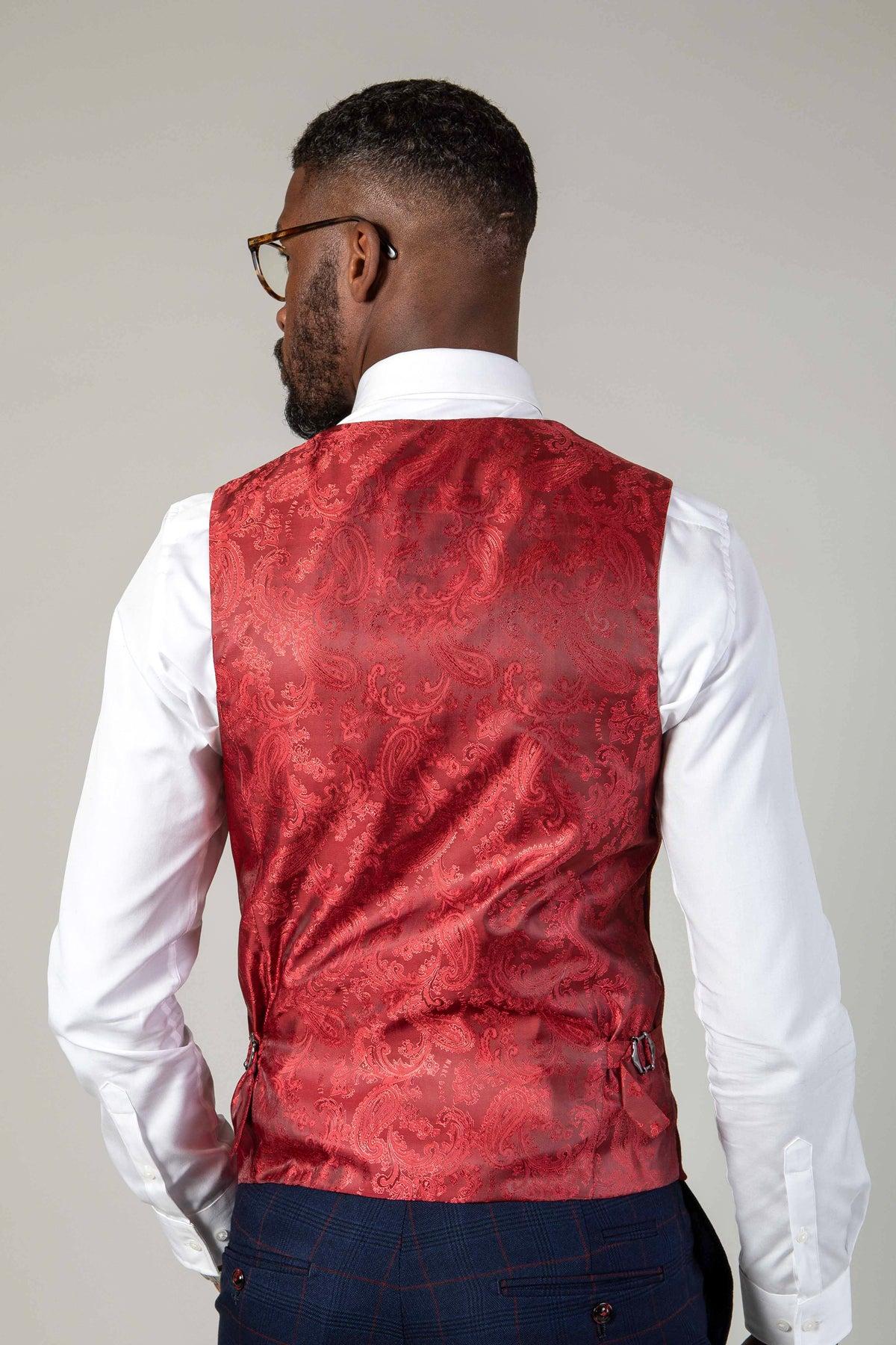 A man with short hair, a beard, and glasses wears a white dress shirt, dark plaid trousers, and the marcdarcy KELVIN - Wine Double Breasted Waistcoat. He is facing away from the camera against a plain light background.