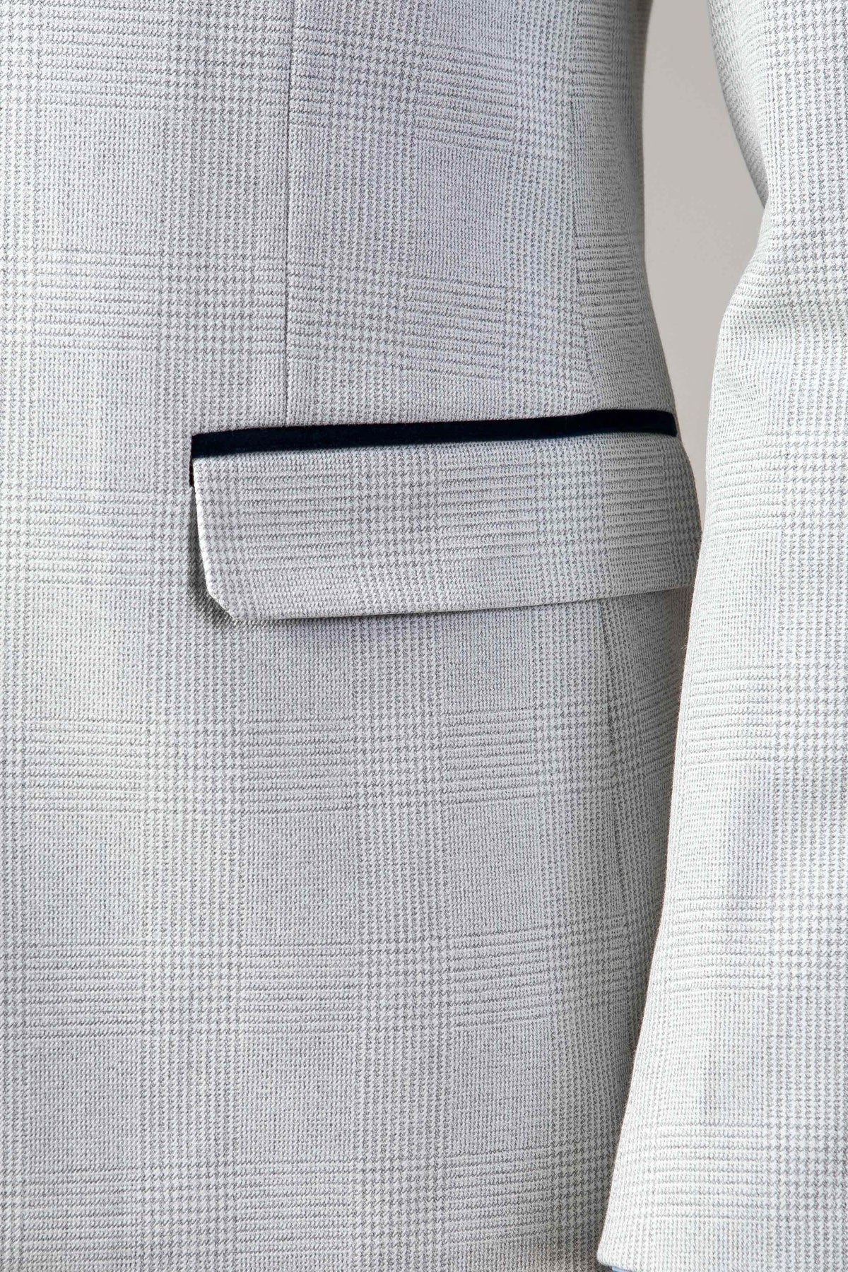 Close-up of the Marc Darcy BROMLEY stone check suit blazer, featuring a subtle checked pattern, flap pocket, and dark trim along the edge. Paired with the Kelvin Pink Waistcoat for a refined look.
