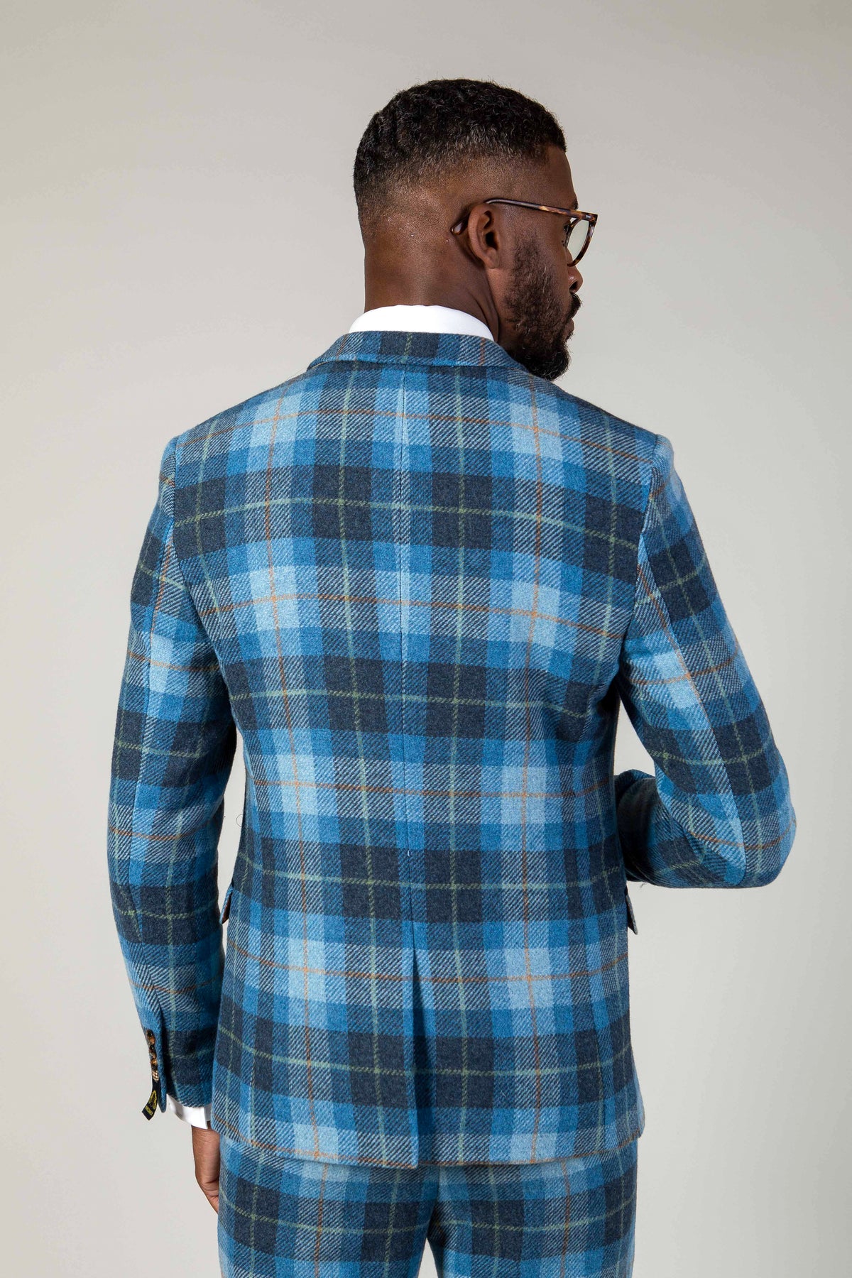 A man in glasses models the Marc Darcy MORRIS Blue Tweed Check Blazer, shown from the back against a plain light background.