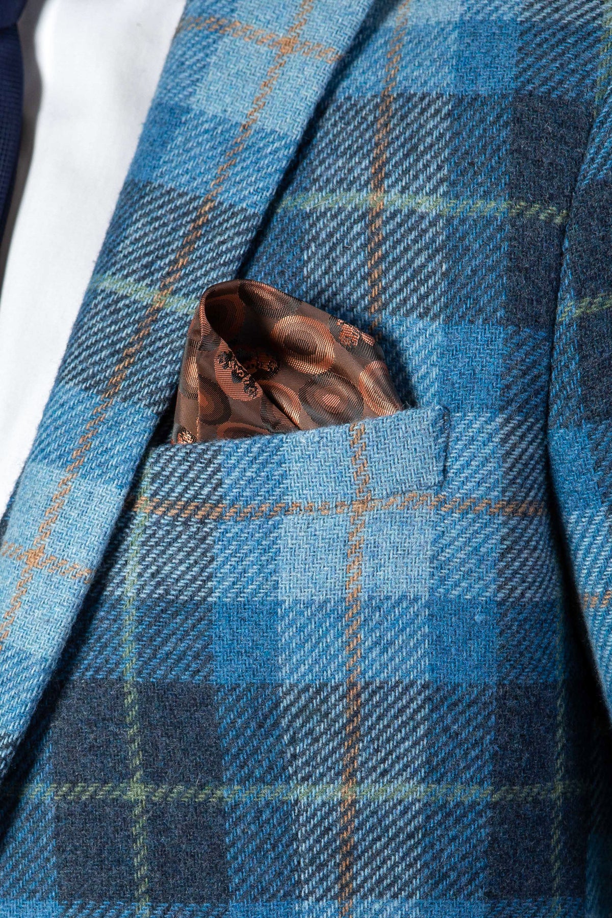 A close-up of the Marc Darcy MORRIS Blue Tweed Check Blazer, featuring brown and orange lines and a brown patterned pocket square in the breast pocket.