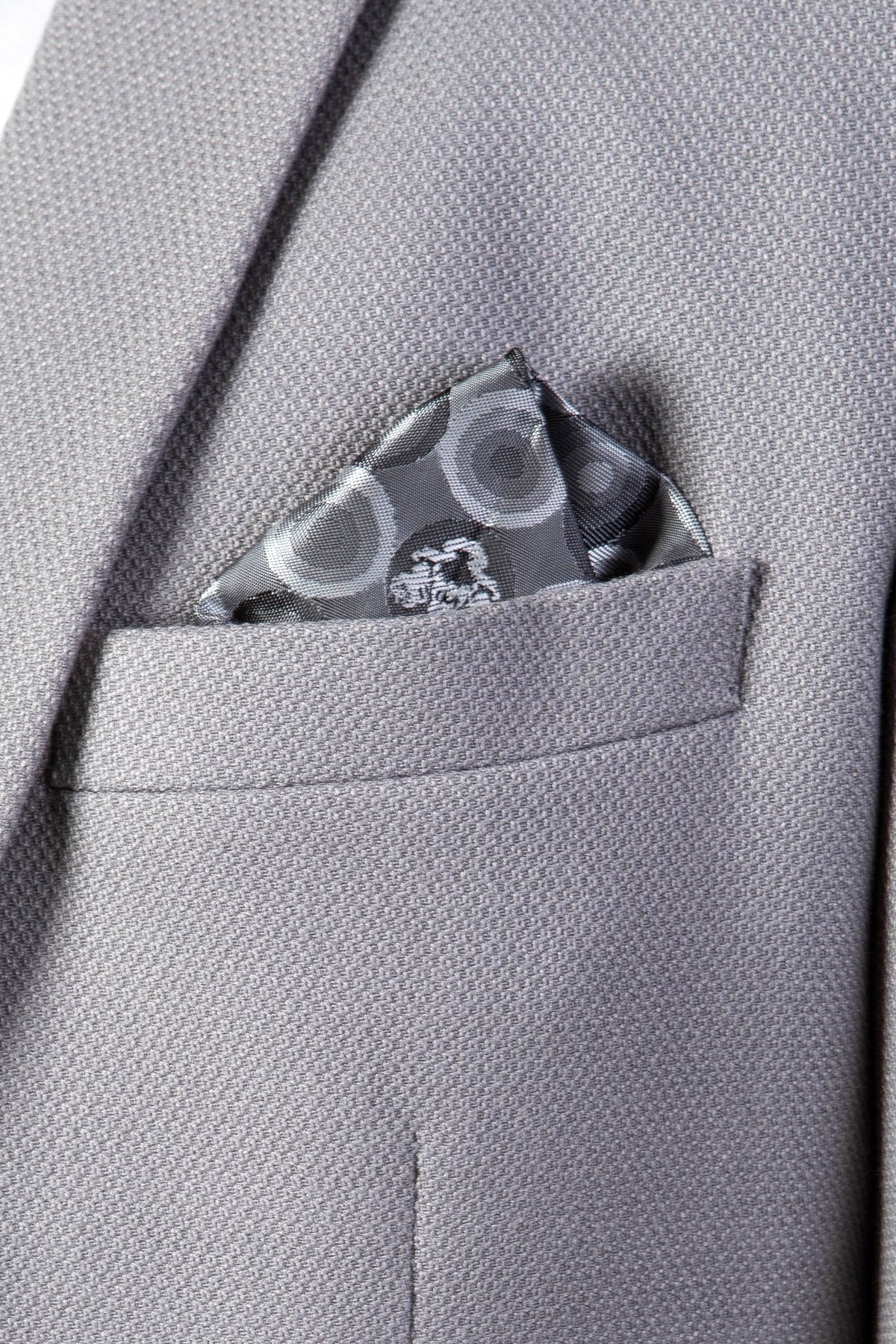 A close-up of the EDWIN Silver Grey Notch Lapel Three Piece Suit by marcdarcy highlights the stylish pocket with a patterned grey square, exemplifying the modern elegance of this slim fit blazer.