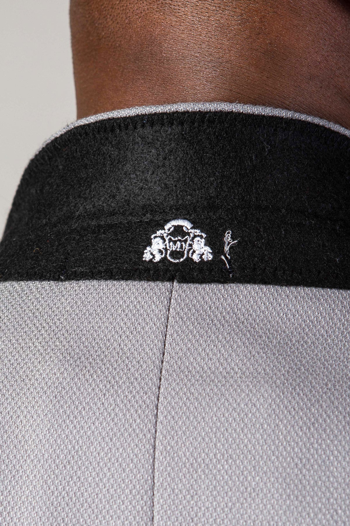 Close-up of the back of a neck wearing the marcdarcy EDWIN Silver Grey Notch Lapel Two Piece Suit, featuring a slim fit and black collar with a small white embroidered design.