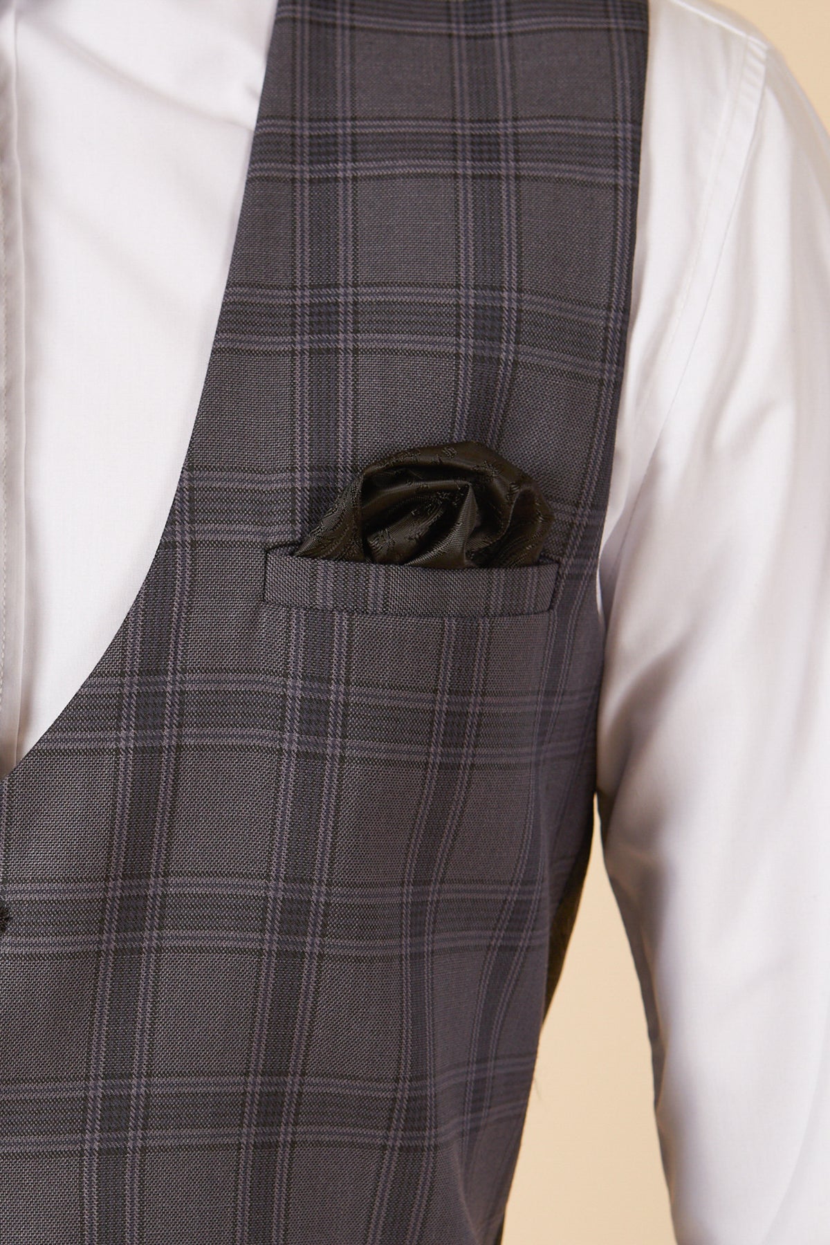 A close-up of a person wearing a white dress shirt and the marcdarcy JOSE - Grey Check Single Breasted Waistcoat, featuring a black pocket square neatly folded in the chest pocket.