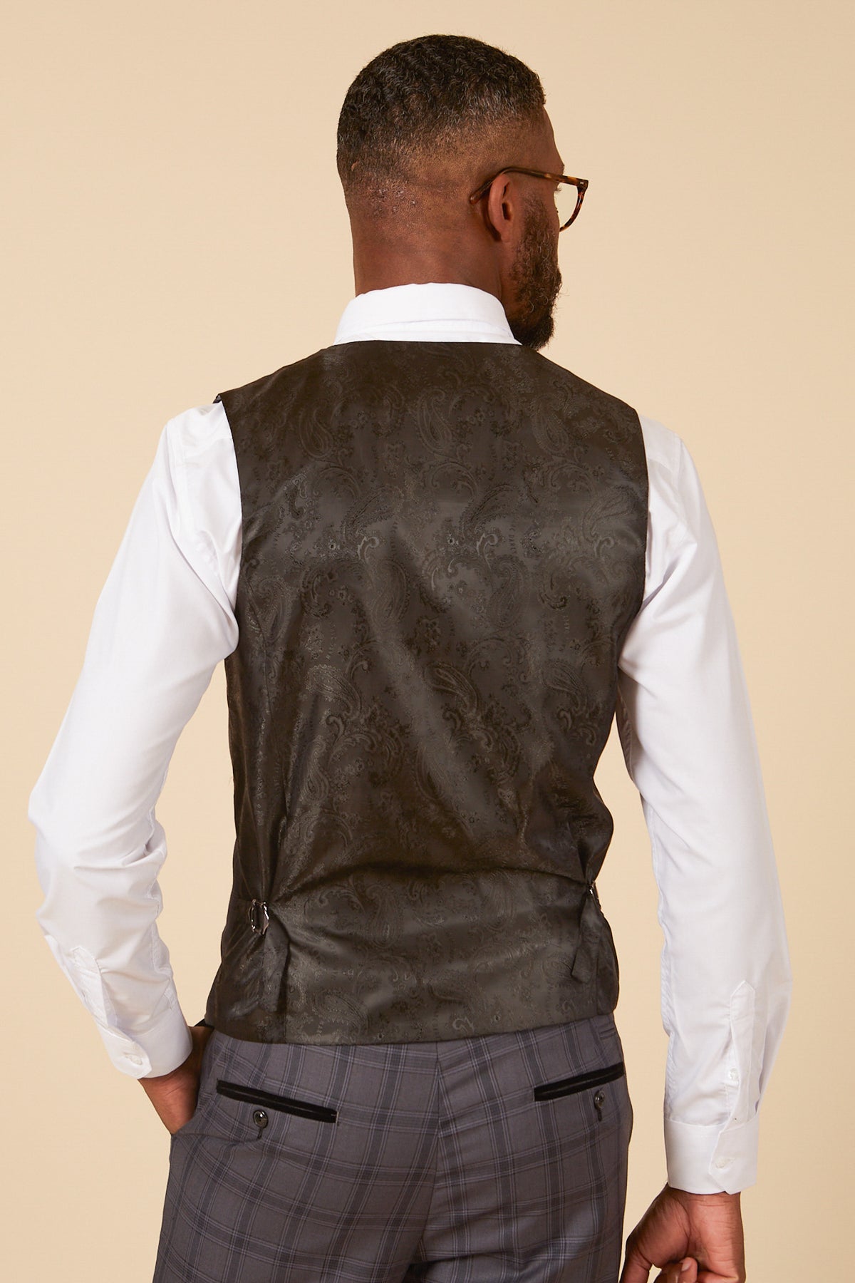 Man wearing the marcdarcy JOSE Grey Check Three Piece Suit—white shirt, dark patterned vest, and grey check pants—viewed from the back.