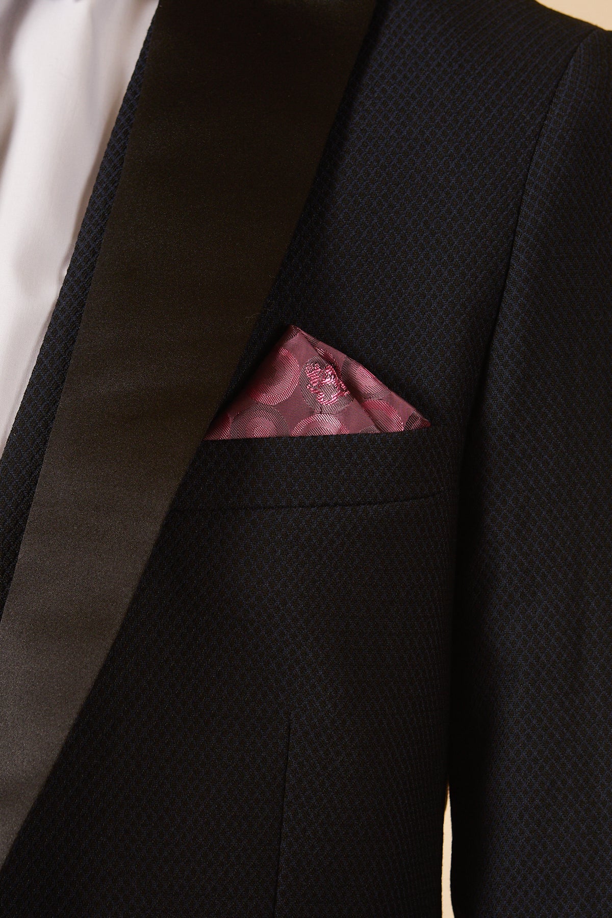 A close-up of a person wearing the marcdarcy DALTON - Navy Tux Lapel Diamond Three Piece Suit with a white dress shirt and pink patterned pocket square.
