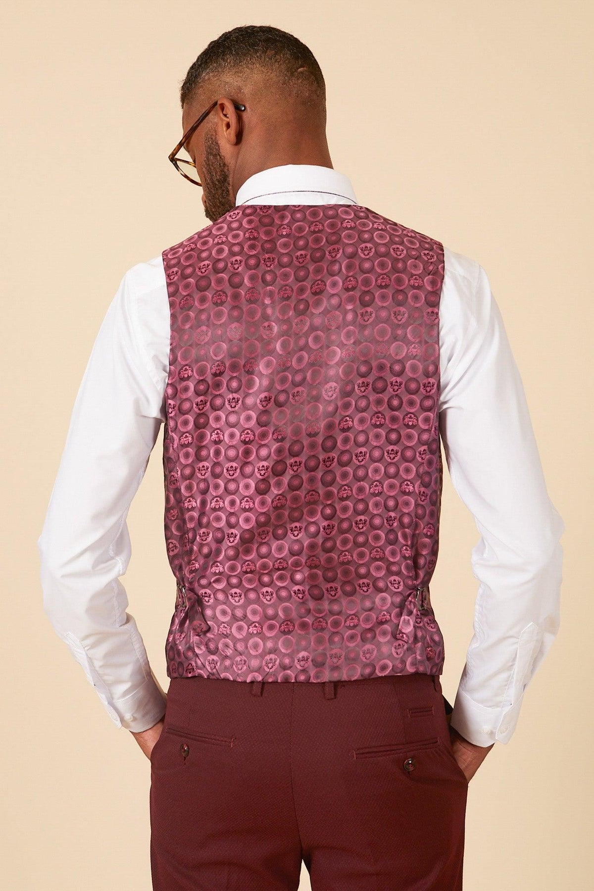 Man in a white dress shirt paired with the marcdarcy MAX - Wine Single Breasted Waistcoat and matching patterned pants—an ideal wedding guest suit.