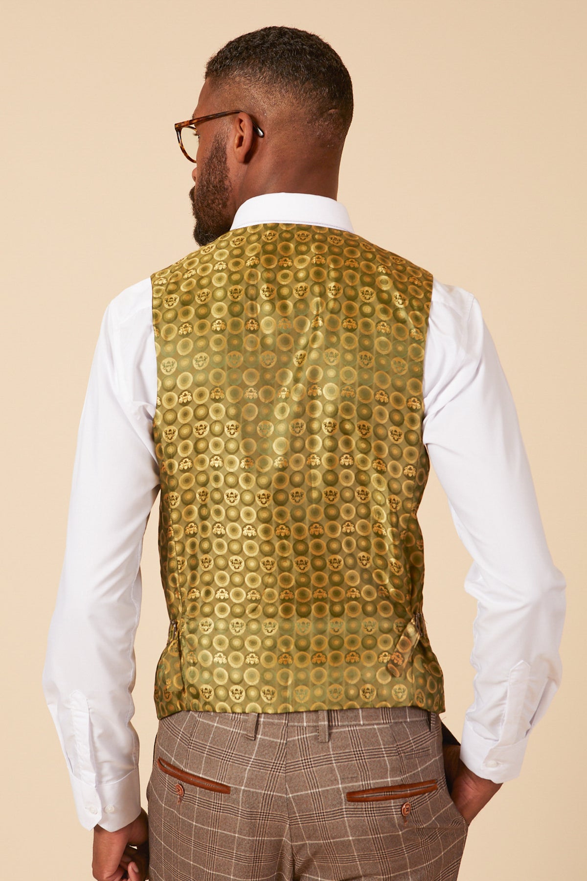 A man with short hair and glasses is seen from the back in a marcdarcy RAY - Tan Check Three Piece Suit, featuring a white shirt and brown Prince of Wales check trousers—ideal for stylish office wear.