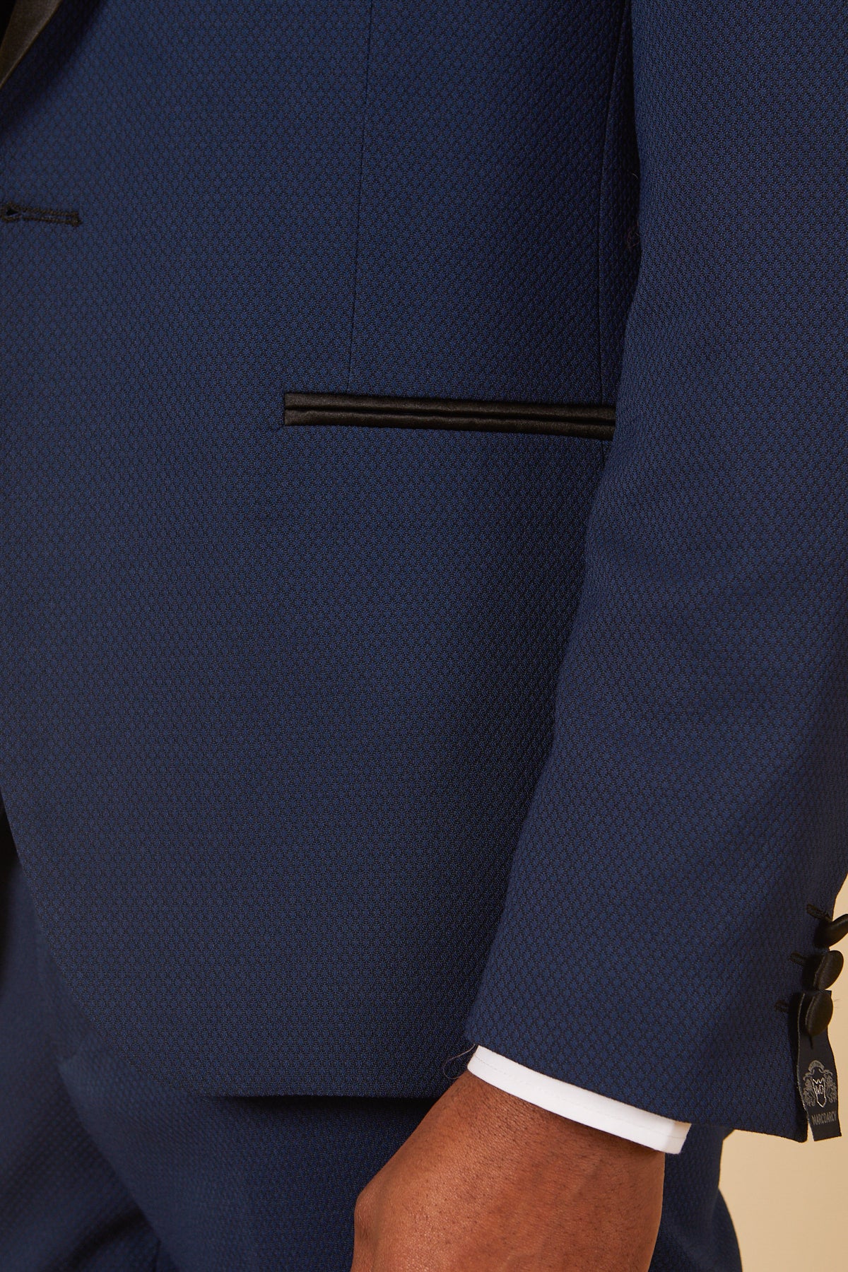 A close-up of a person wearing the marcdarcy DALTON—Royal Blue Tux Lapel Diamond Blazer, featuring black trim on the pocket, tuxedo lapel detail, white shirt cuff, and black sleeve buttons.