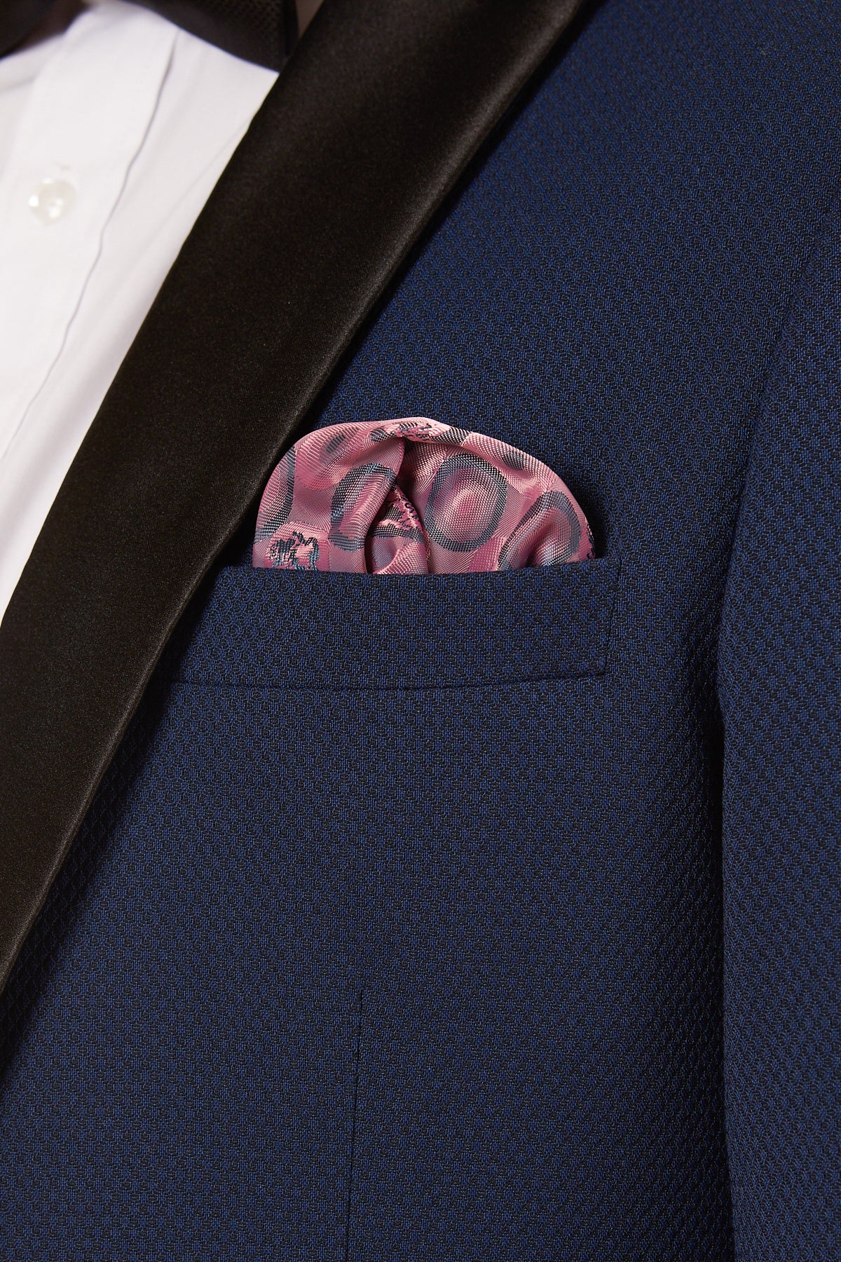 Close-up of a person wearing the marcdarcy DALTON - Royal Blue Tux Lapel Diamond Blazer, styled with a white dress shirt and a pink patterned pocket square in the breast pocket.