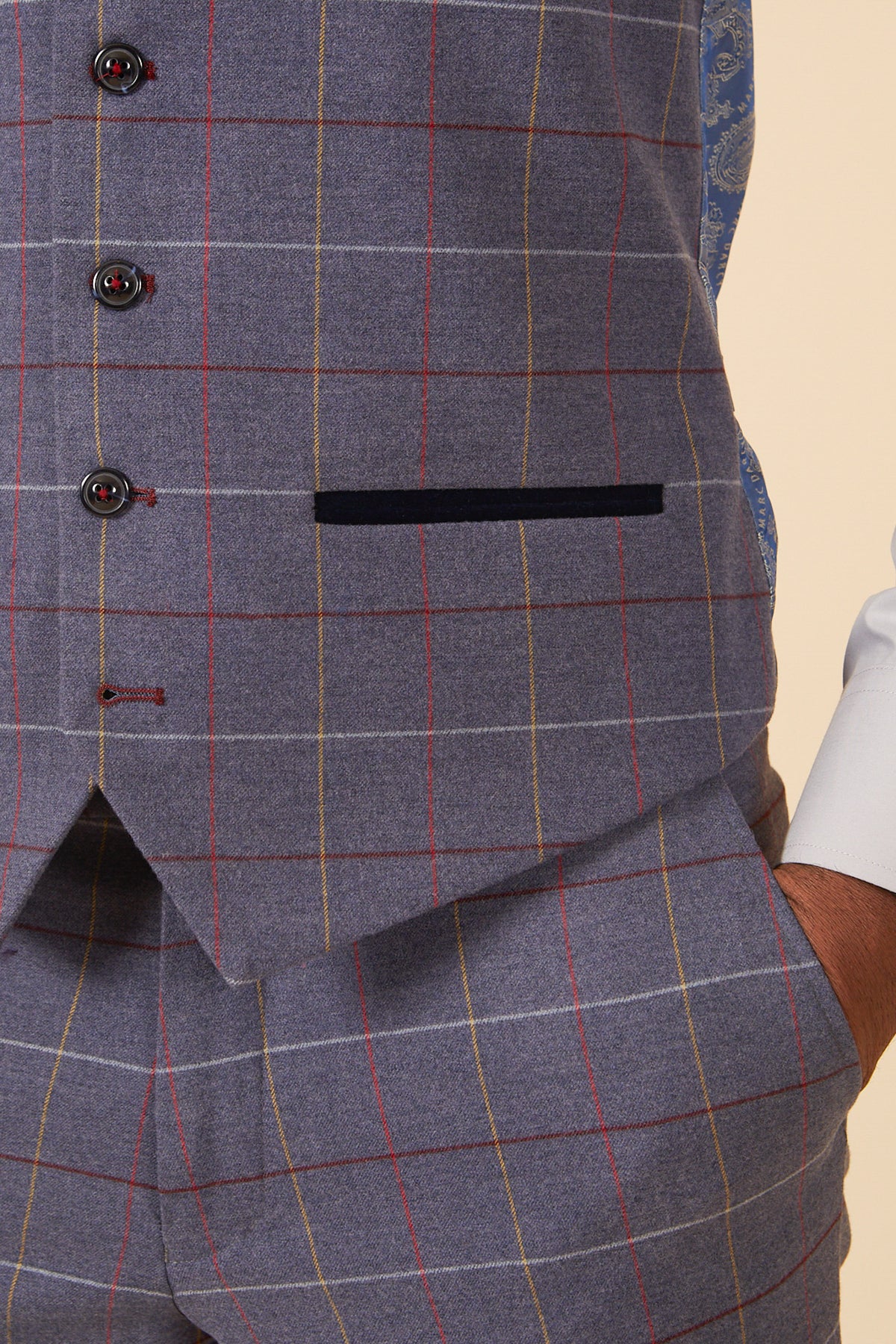 Close-up of a person wearing the marcdarcy DRAKE Sky Blue Check Three Piece Suit, featuring dark buttons, a pocket, and paired with a white shirt sleeve and one hand in the pants pocket—ideal for formal occasions.