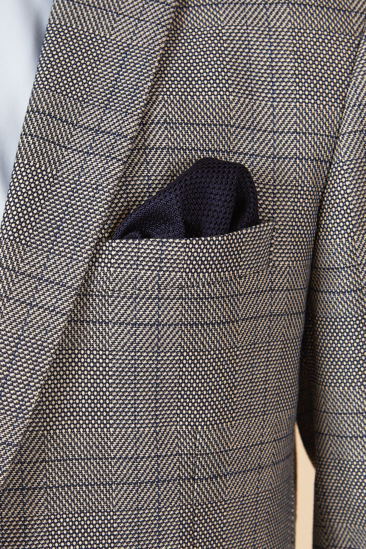 Close-up of the marcdarcy JERRY grey check suit with a single breasted waistcoat, featuring a textured dark navy pocket square in the chest pocket.