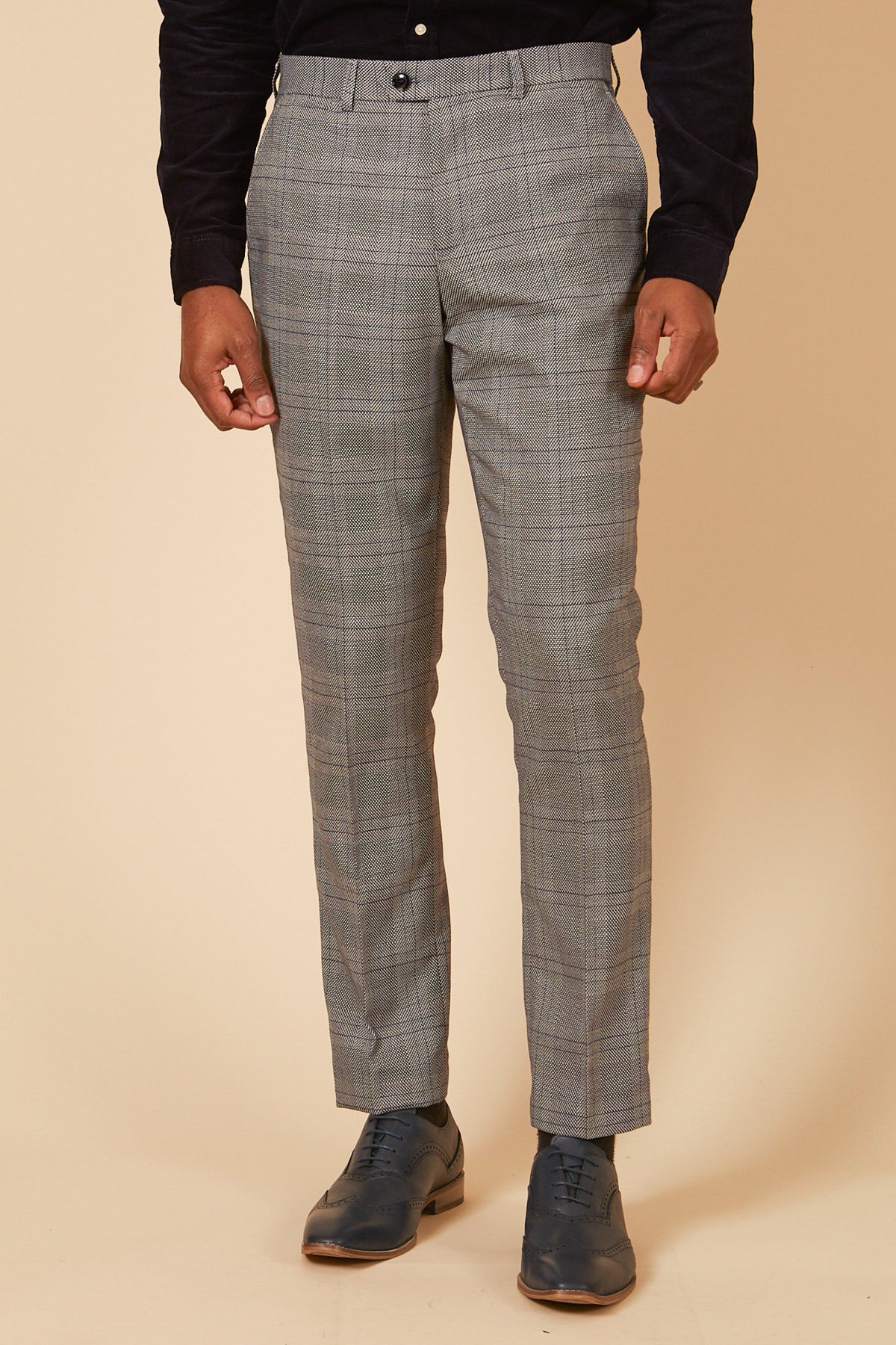 Wearing the marcdarcy JERRY Grey Check Suit With Single Breasted Waistcoat, a person stands against a beige background—cropped from shoulders down. The look is paired with a dark shirt and blue dress shoes, perfect to style with a slim fit blazer.