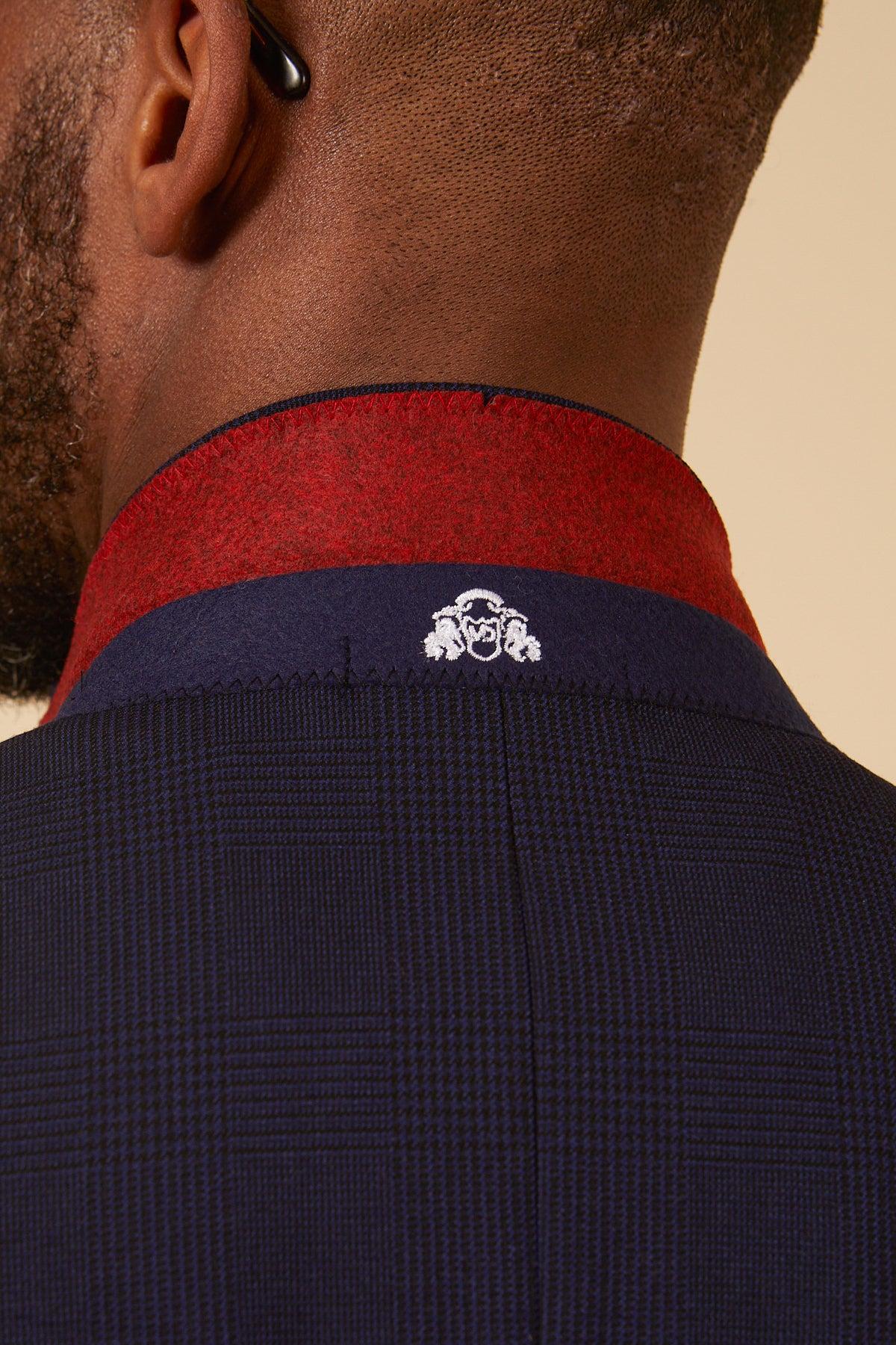 Close-up of the collar on the Marc Darcy BROMLEY Navy Check Two Piece Suit. The navy plaid blazer features a red-lined collar and a white embroidered crest, offering a modern twist on classic Prince of Wales check.
