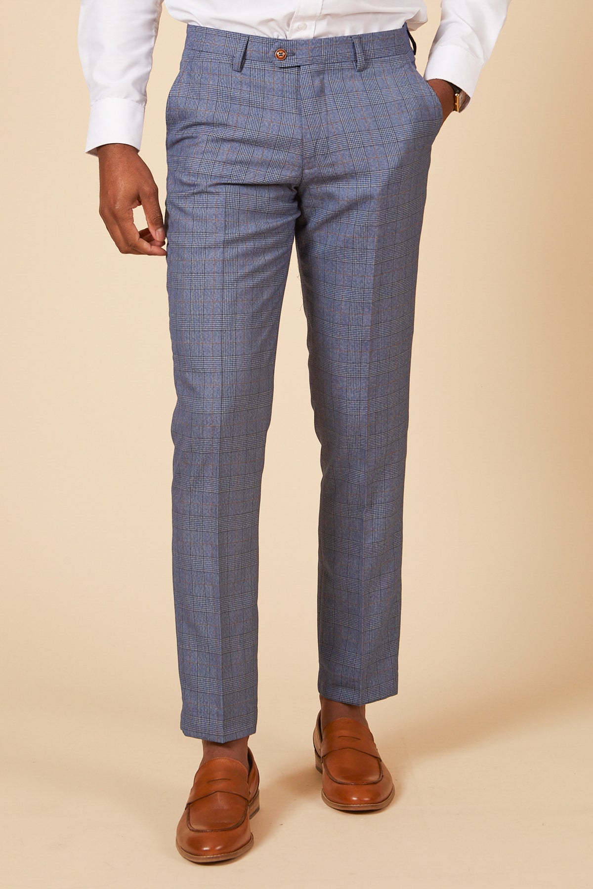 A person wearing the marcdarcy GEORGE Light Blue Check Three Piece Suit stands against a beige background, styled with a brown belt, white shirt, and brown dress shoes.
