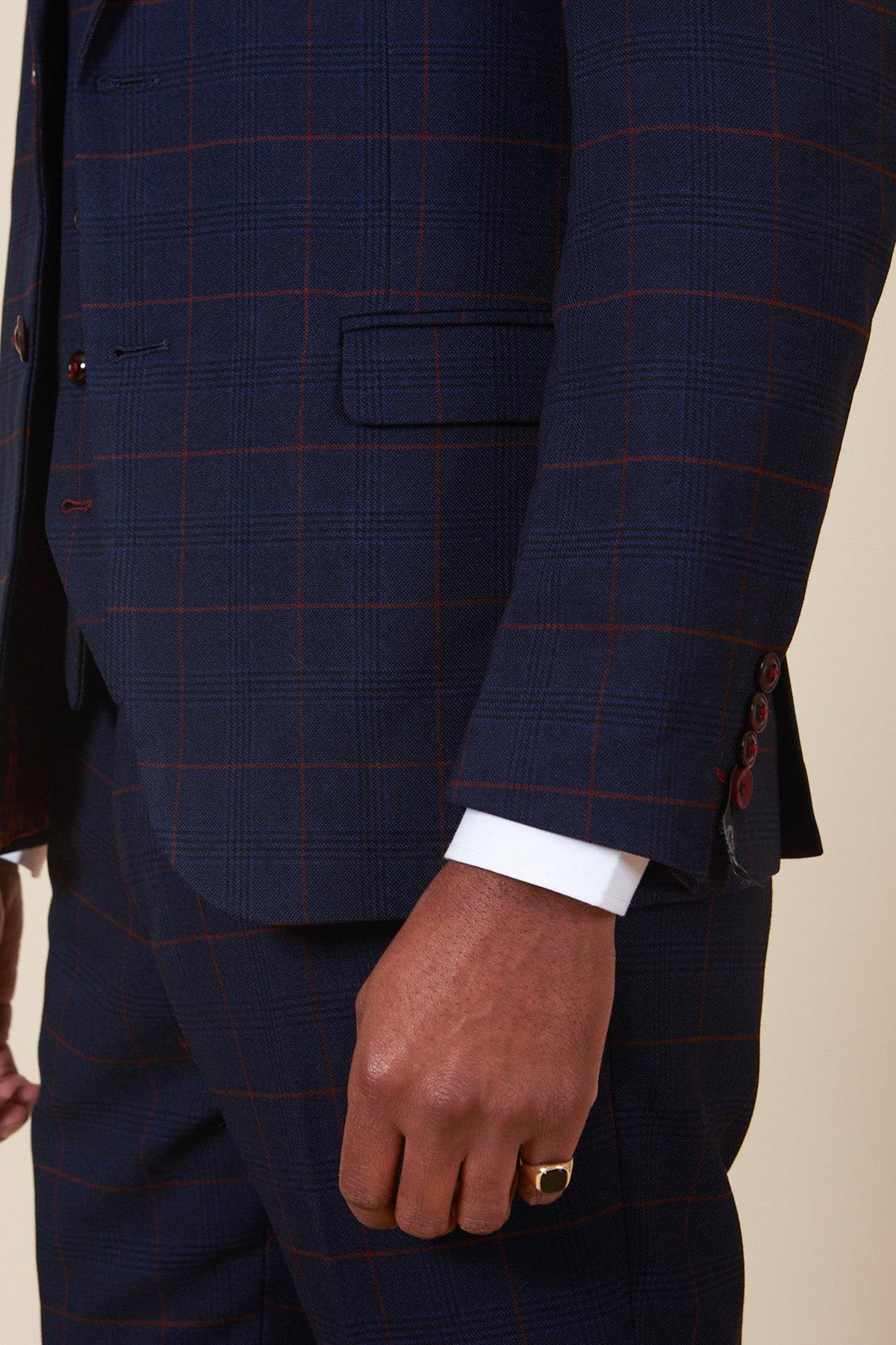 A person wears the Marc Darcy EDINSON Navy Wine Check Two Piece Suit with a white dress shirt and gold ring, focusing on lower torso, hip, and hand.