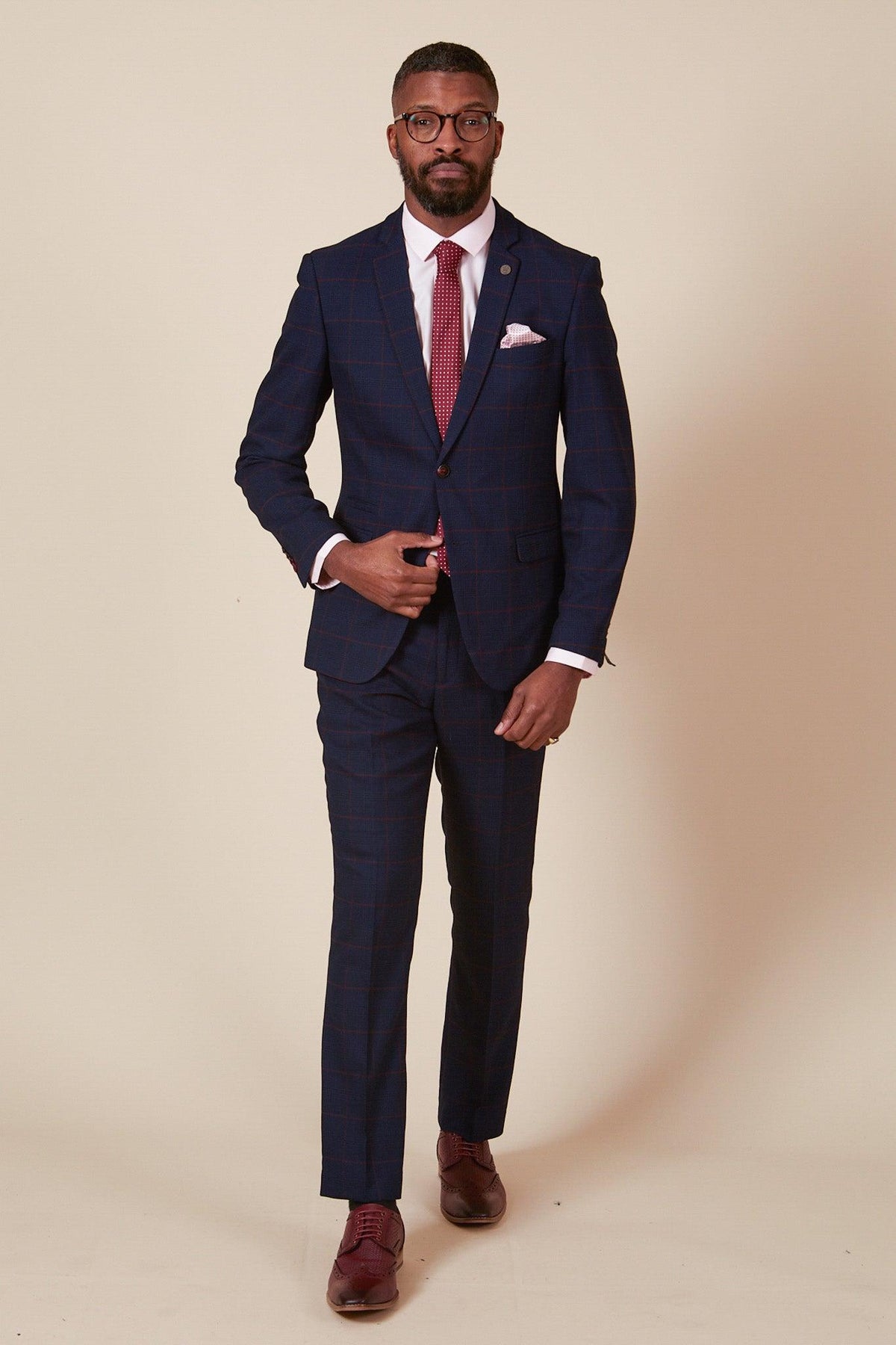 A man wearing the Marc Darcy EDINSON Navy Wine Check Two Piece Suit stands against a beige background, looking directly at the camera.