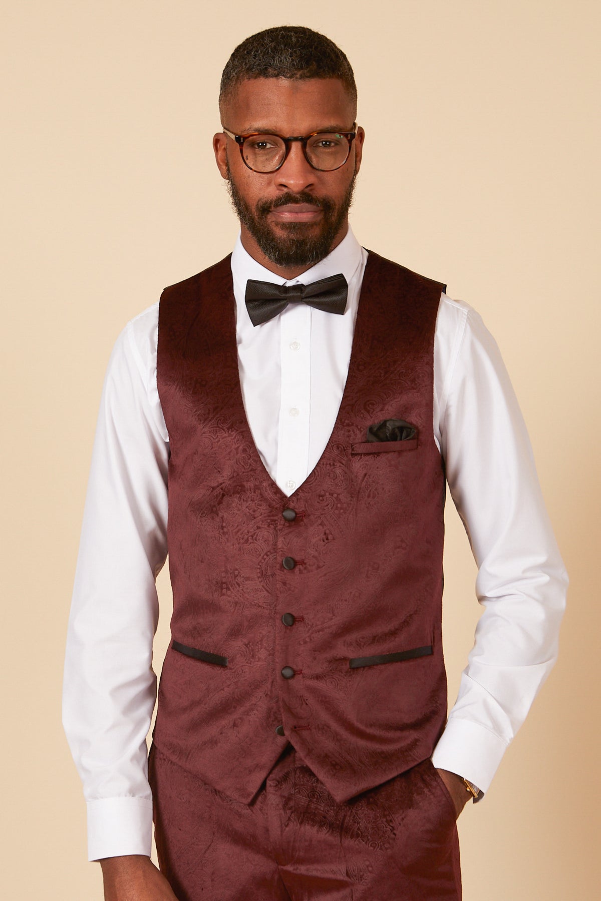 A Black man wearing the Marc Darcy SIMON Wine Velvet Jacquard Three Piece Suit with a white shirt, black bowtie, and glasses—perfect for party wear.