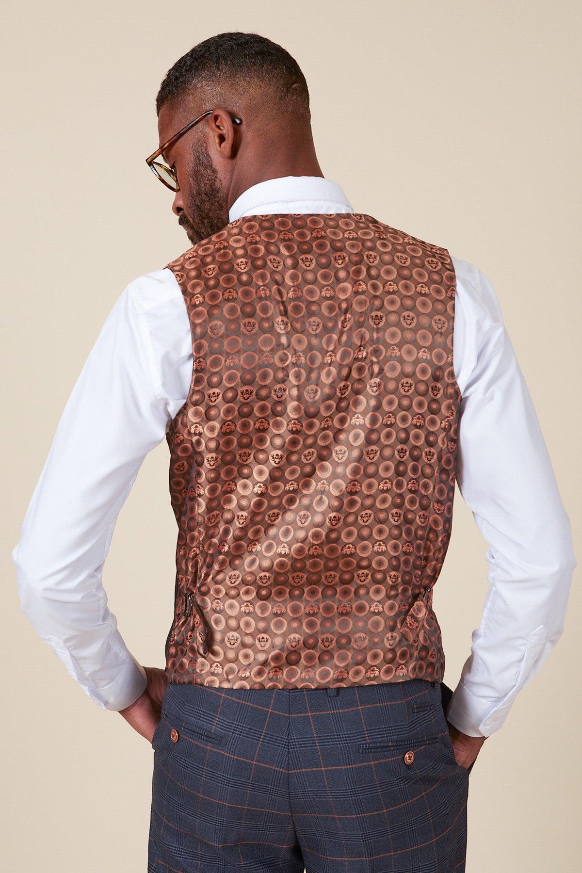 A man in glasses and a white shirt is seen from behind, showcasing the marcdarcy JENSON Marine Navy Check Double Breasted Waistcoat and slim fit gray Prince of Wales check trousers with brown buttons.